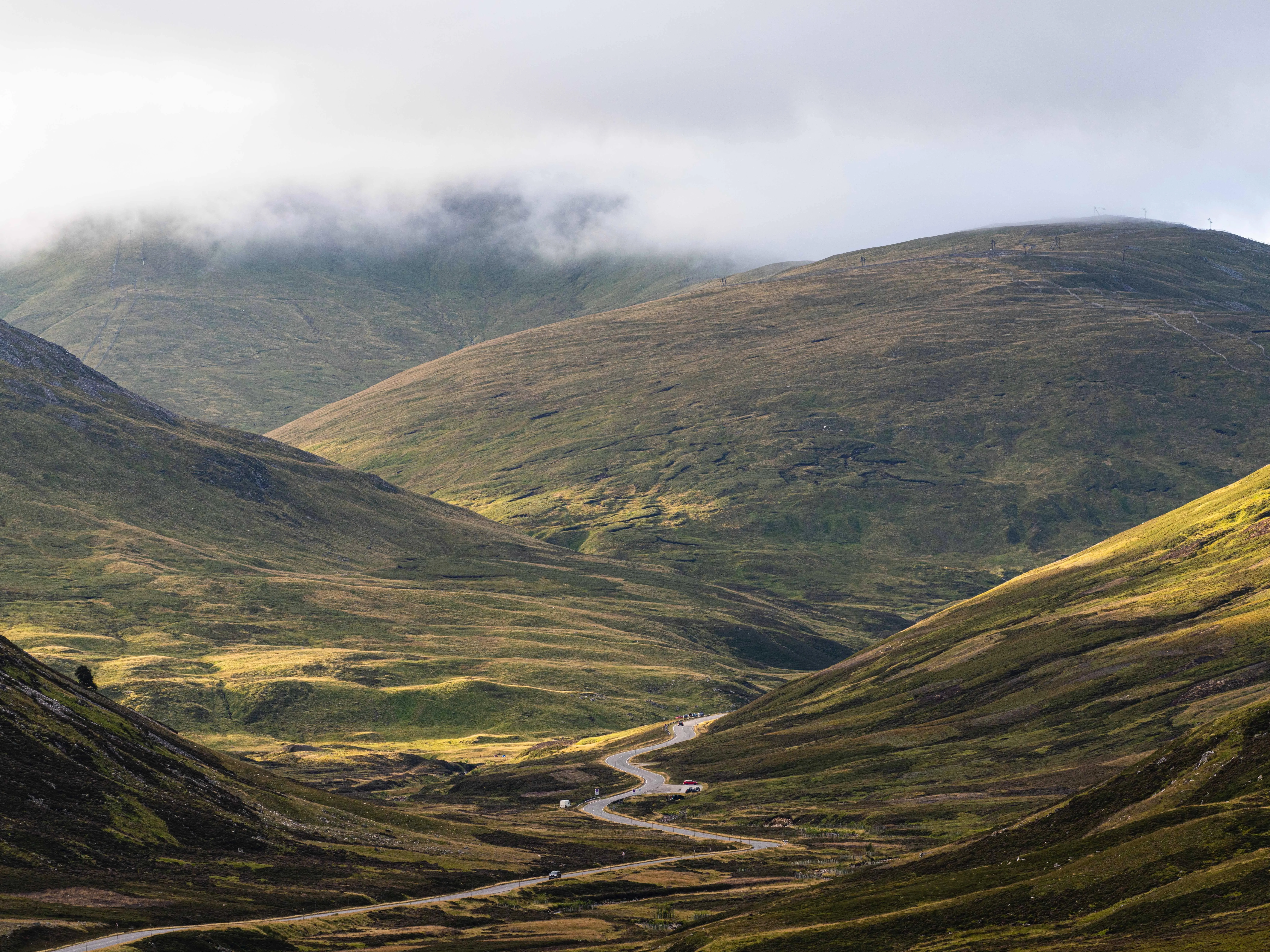 Rolling Hills Covered with Green Grass and Clouds Wallpaper