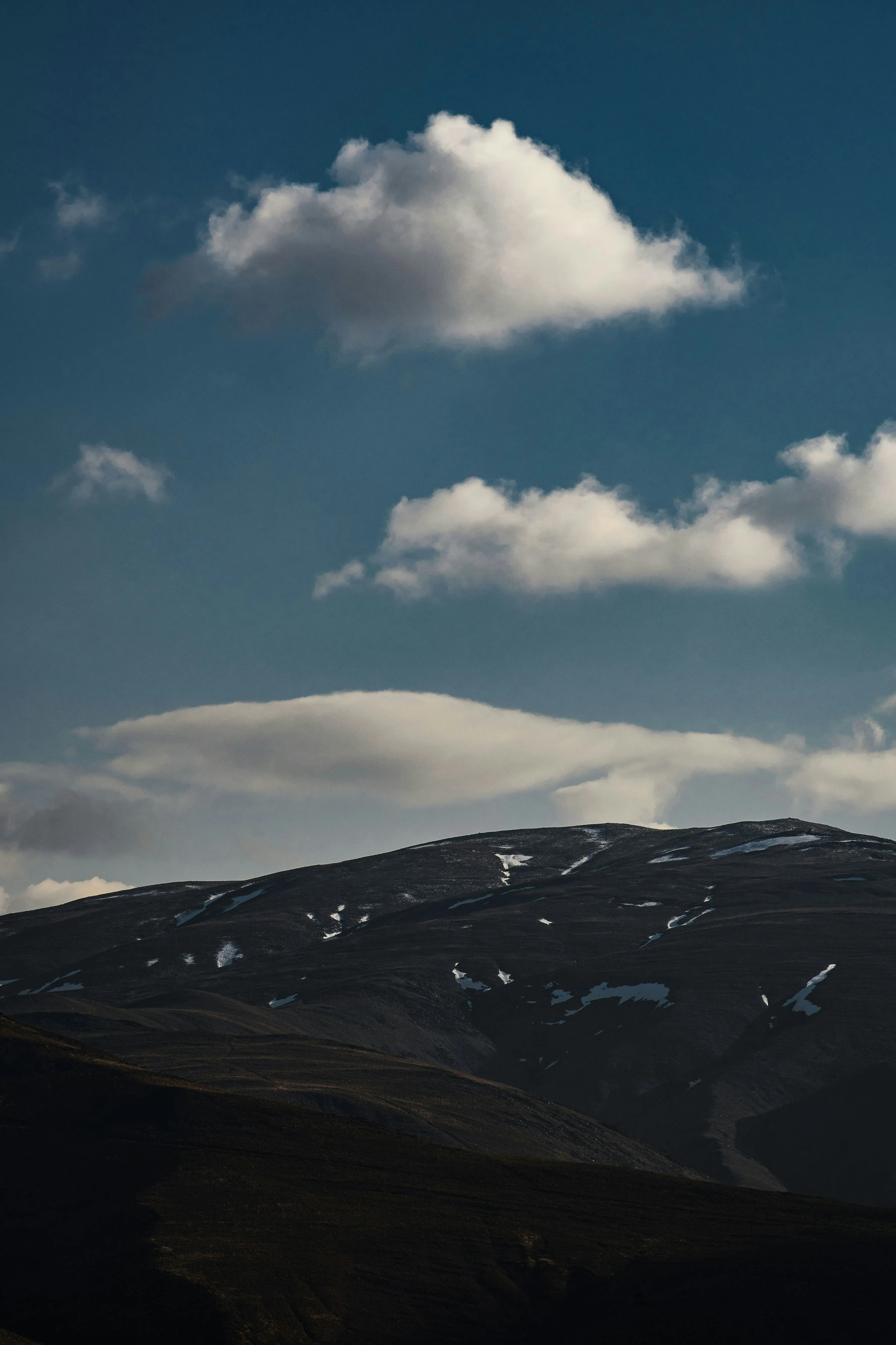 Rolling Hills Under Dark Sky with Mountain Cloud View
