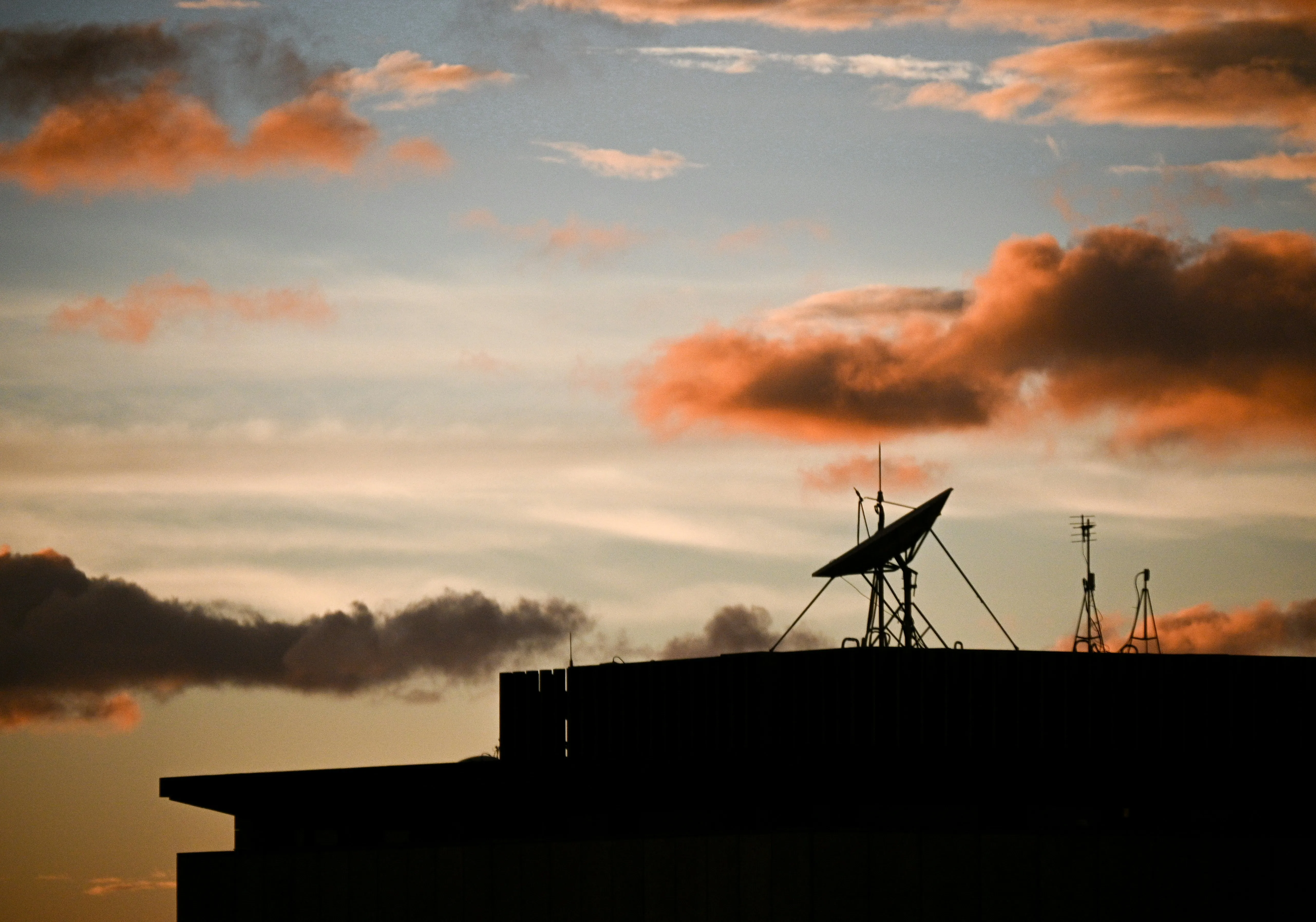 Rooftop Silhouette Under a Vivid Sunset Sky HD Image