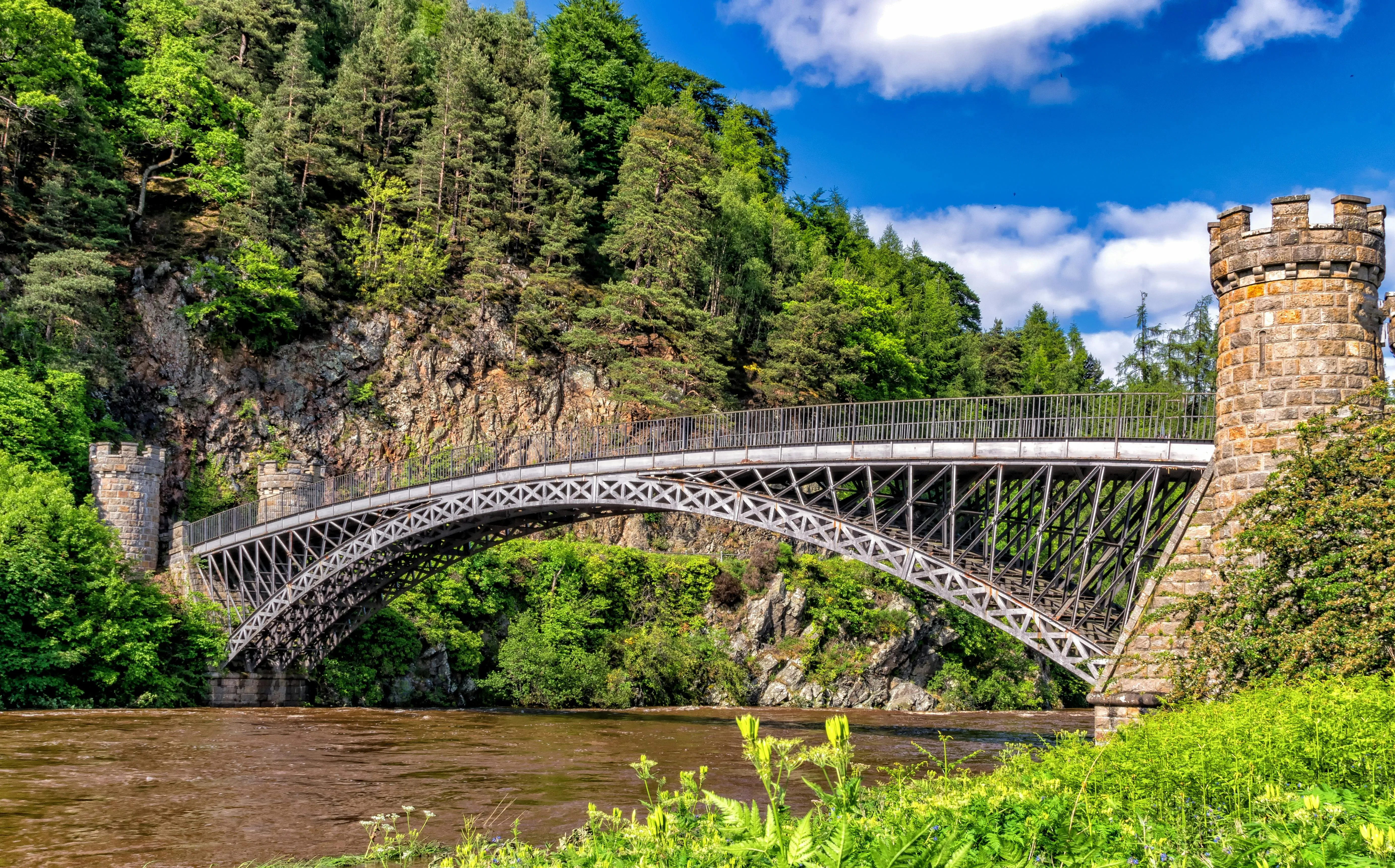 Scenic Iron Bridge Crossing River in Lush Green Forest Hills