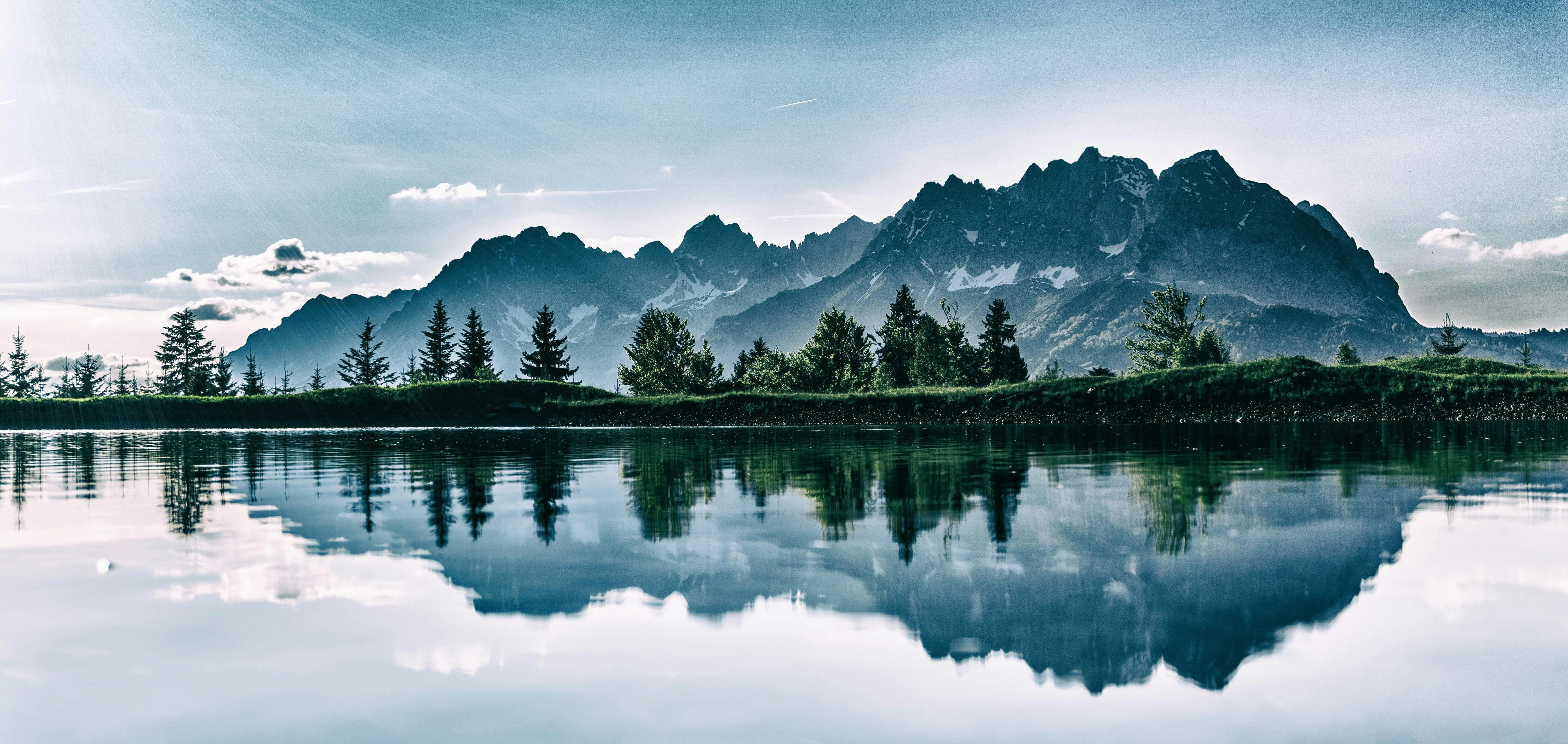 Scenic Lake Reflection Under Cloudy Mountain Sky Wallpaper