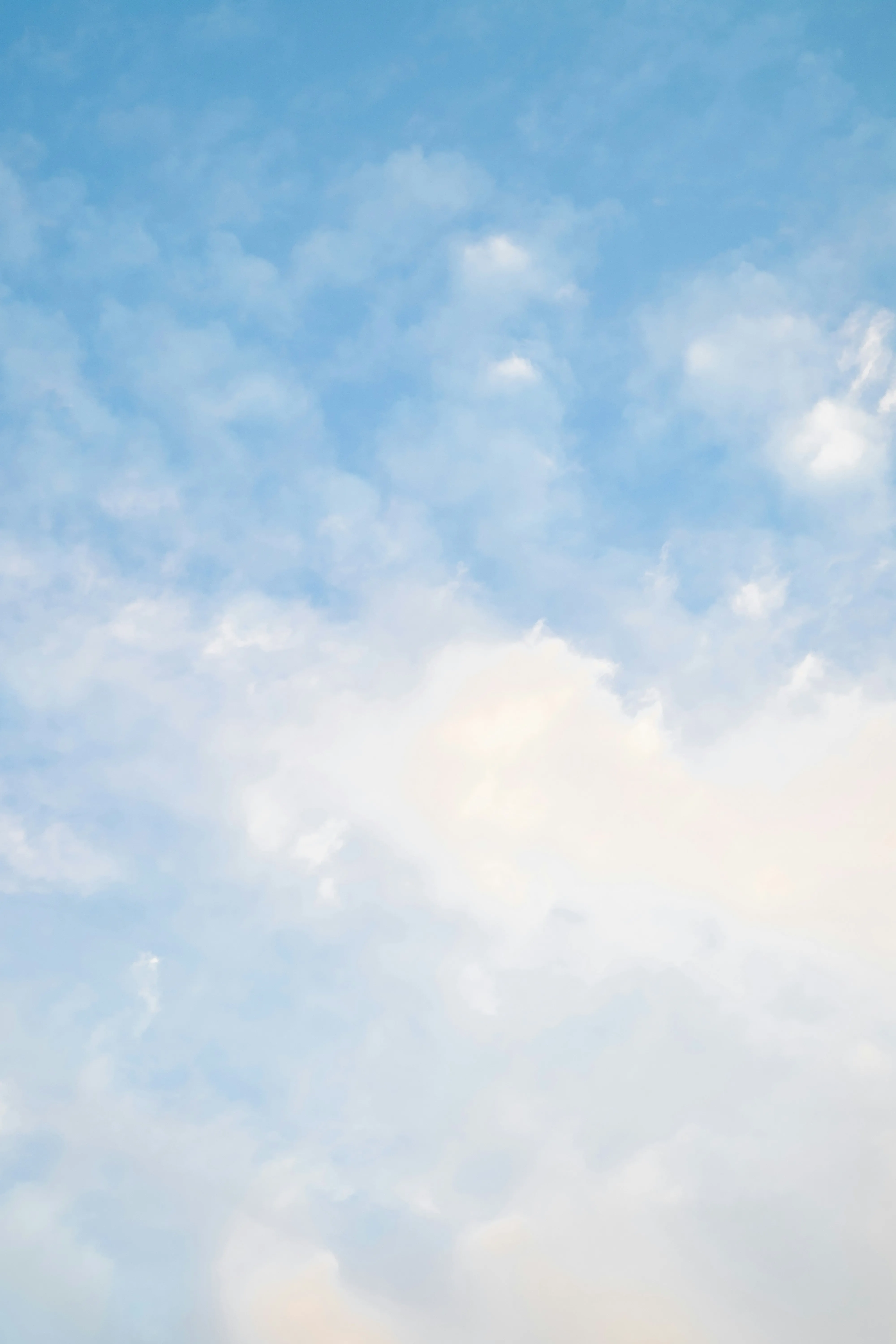 Serene Blue Sky with Soft White Clouds on a Calm Day