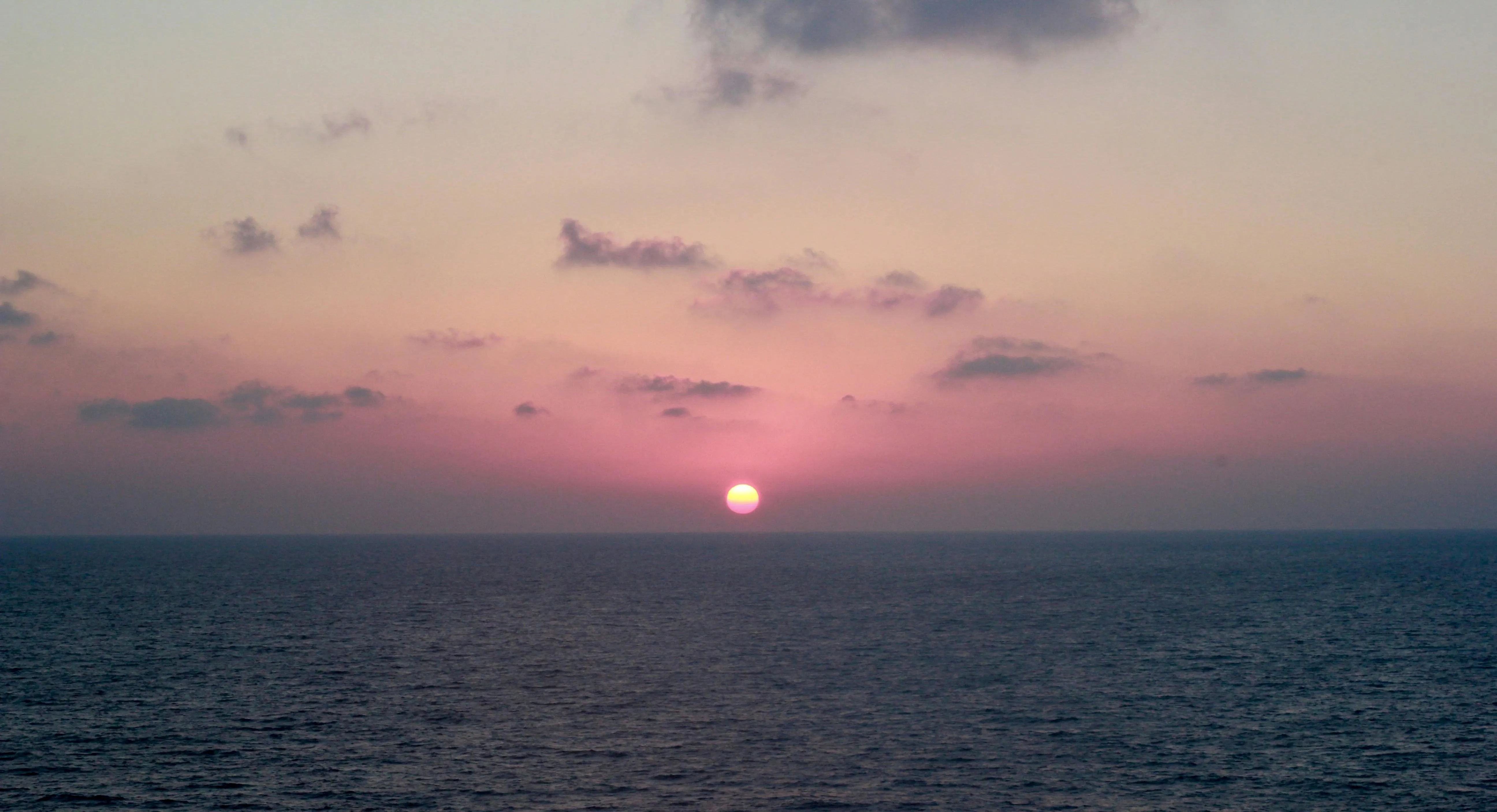 Serene Ocean Sunset with Faint Clouds Above Horizon