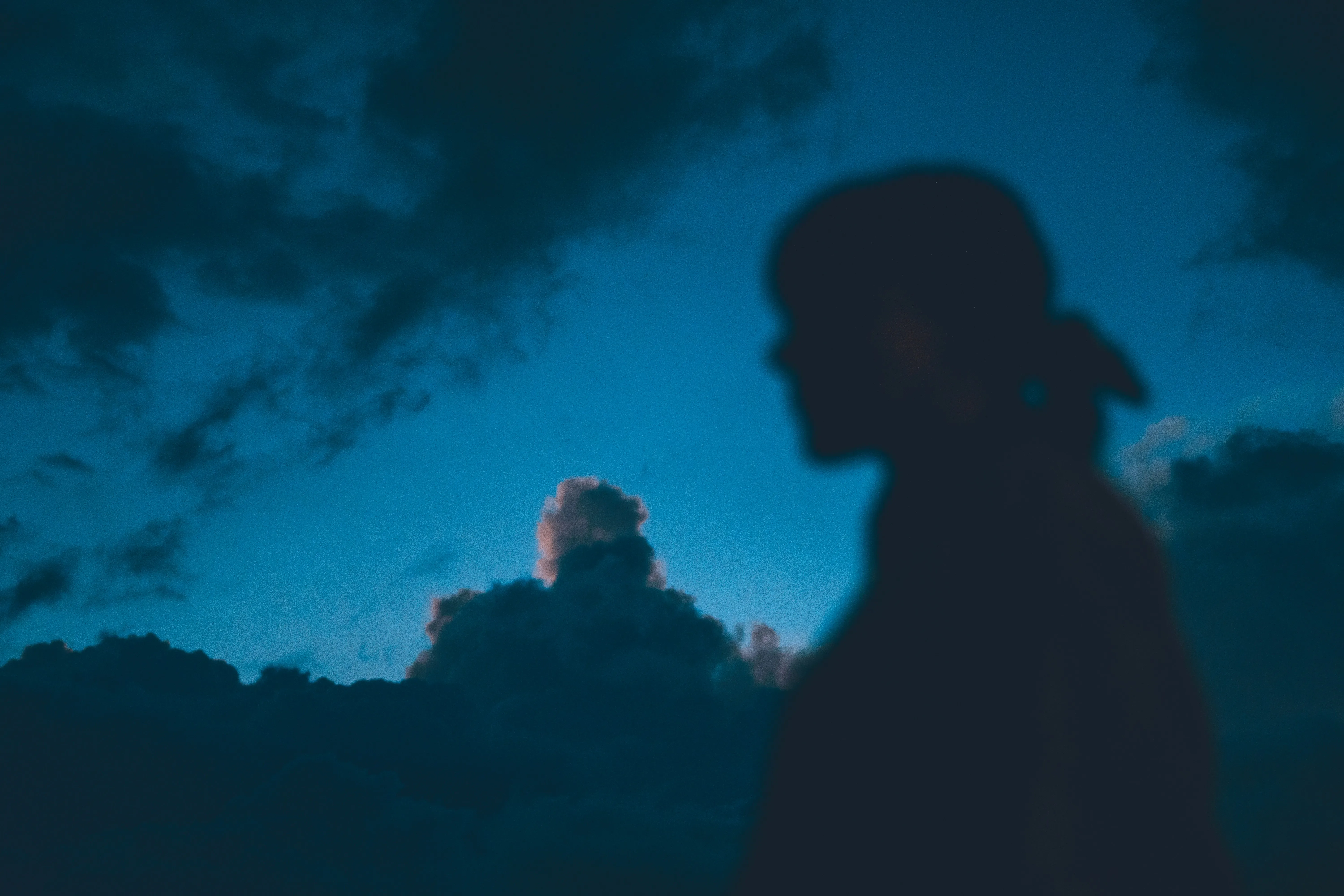 Silhouette of Person Against Dramatic Cloudy Evening Sky
