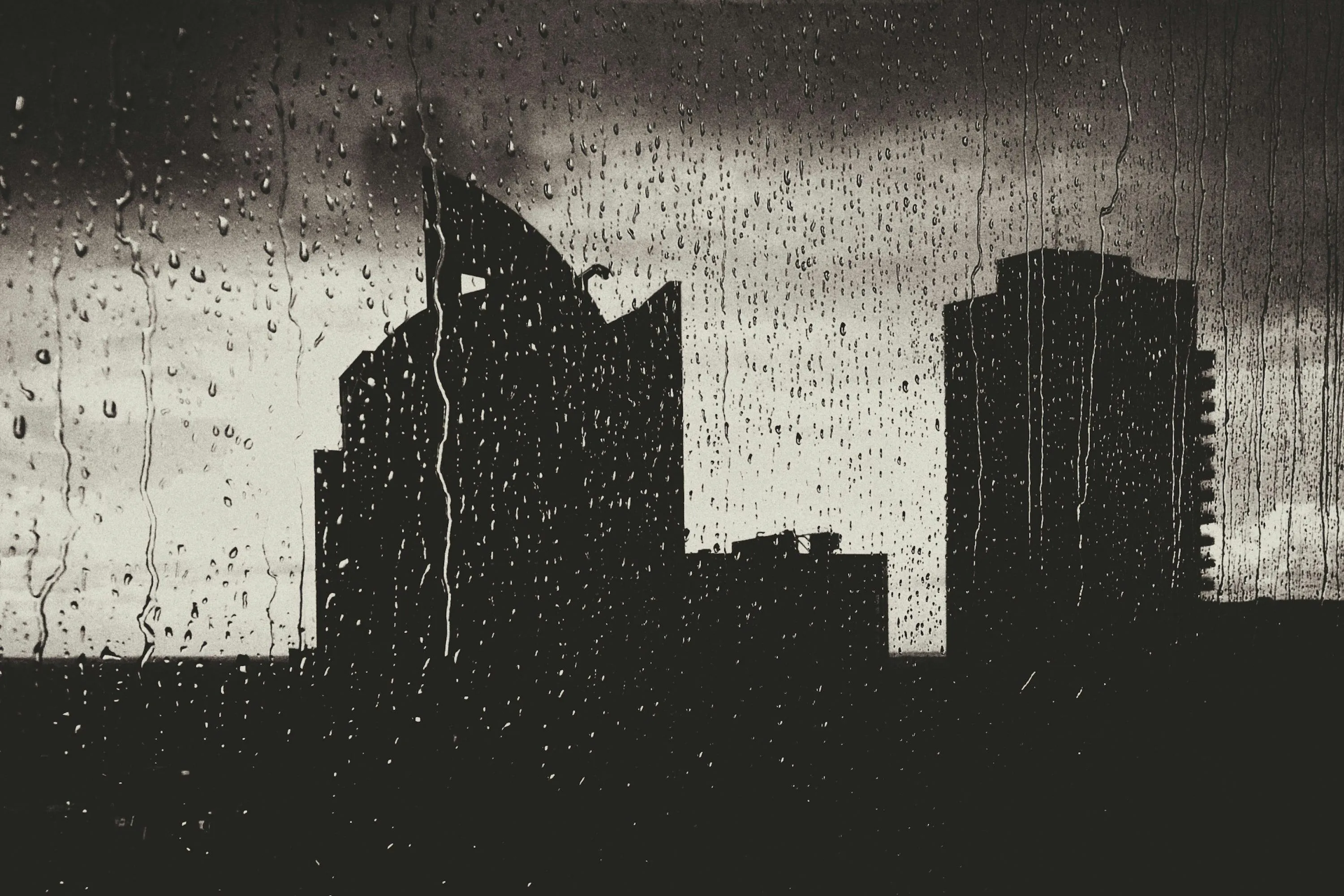 Silhouetted Buildings During Heavy Rain Free Wallpaper
