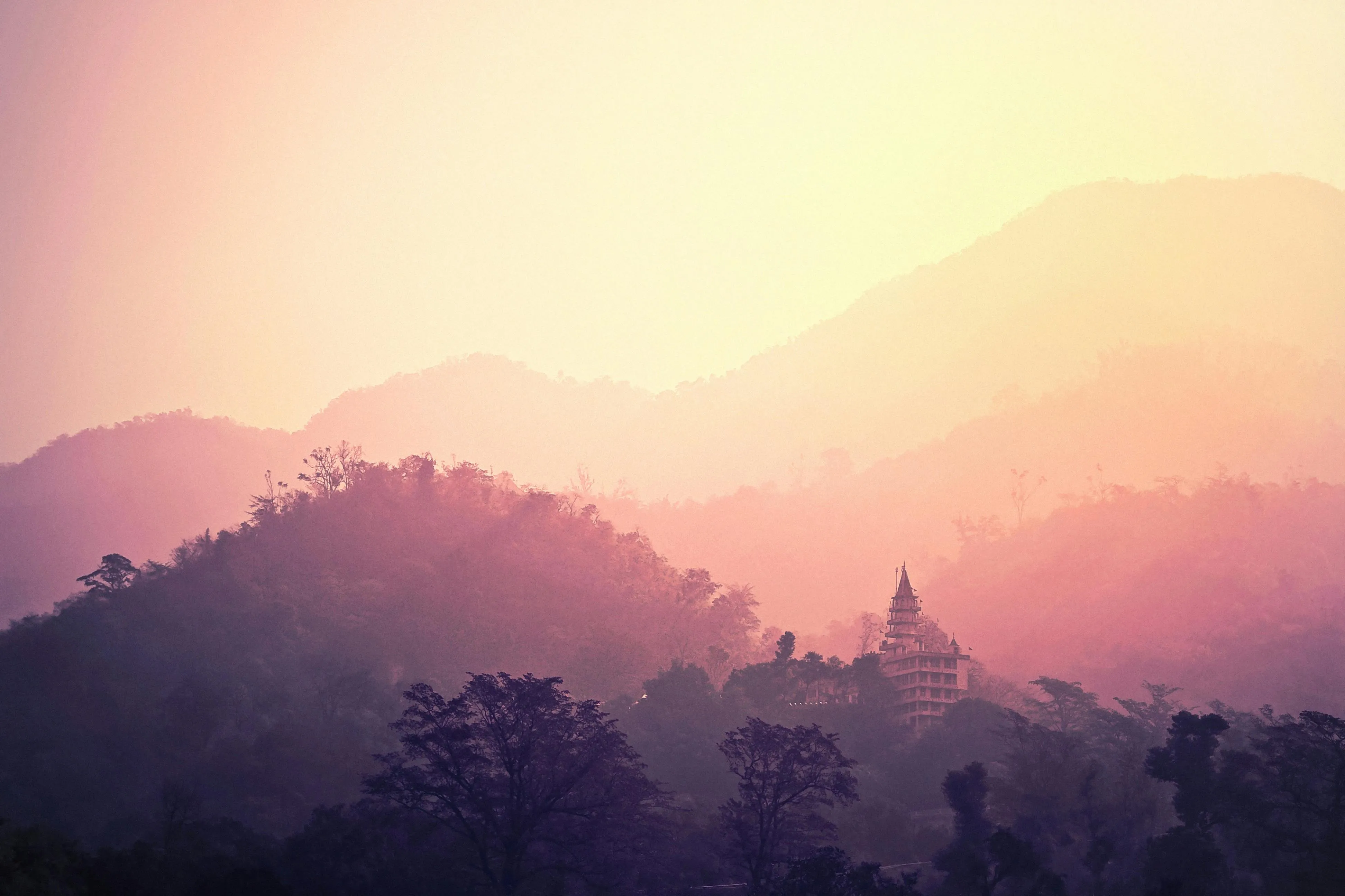 Silhouetted Forest Mountains in Warm Pinkish Sunrise