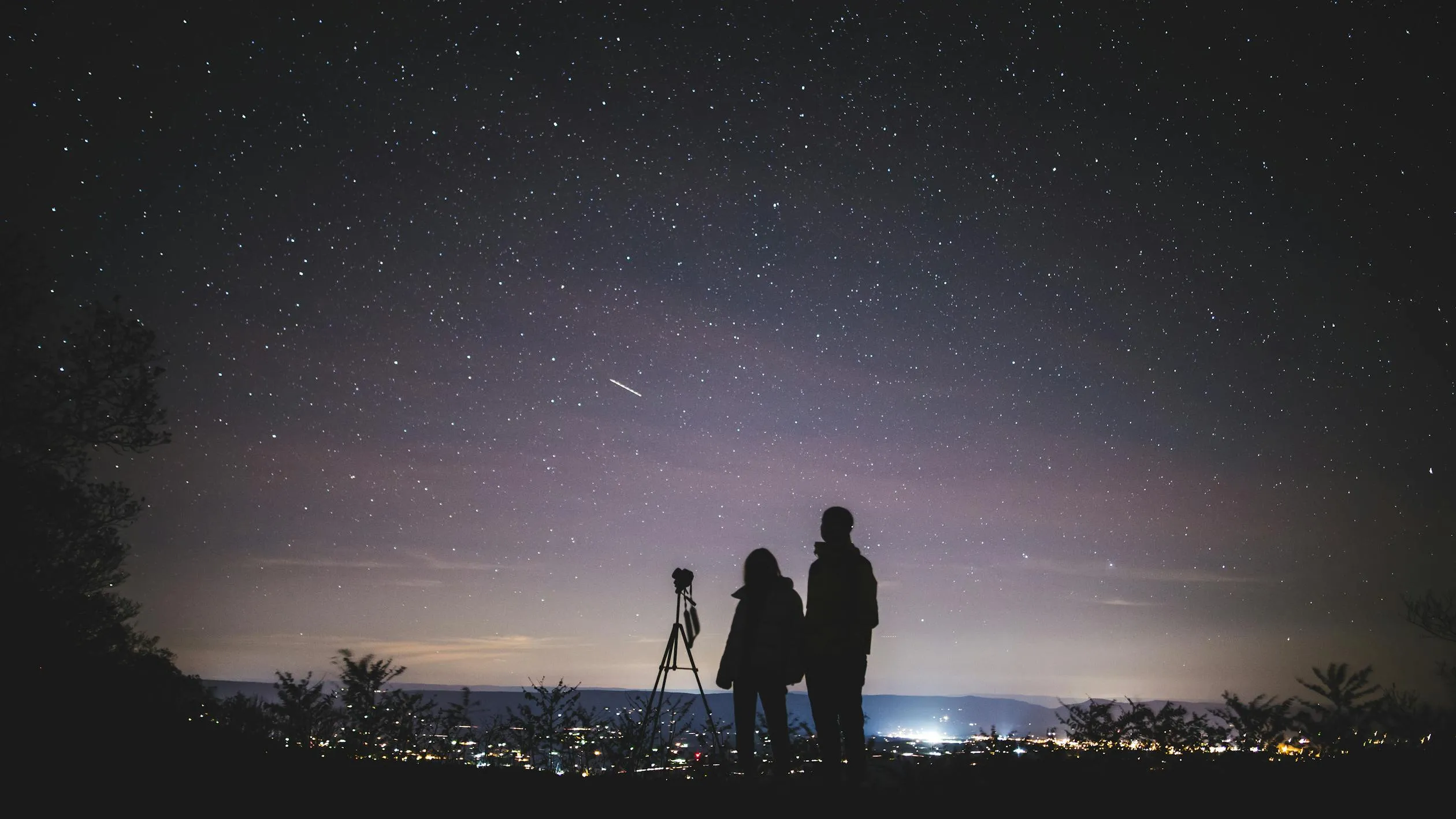 Silhouetted People Standing Under Night Sky Full of Stars