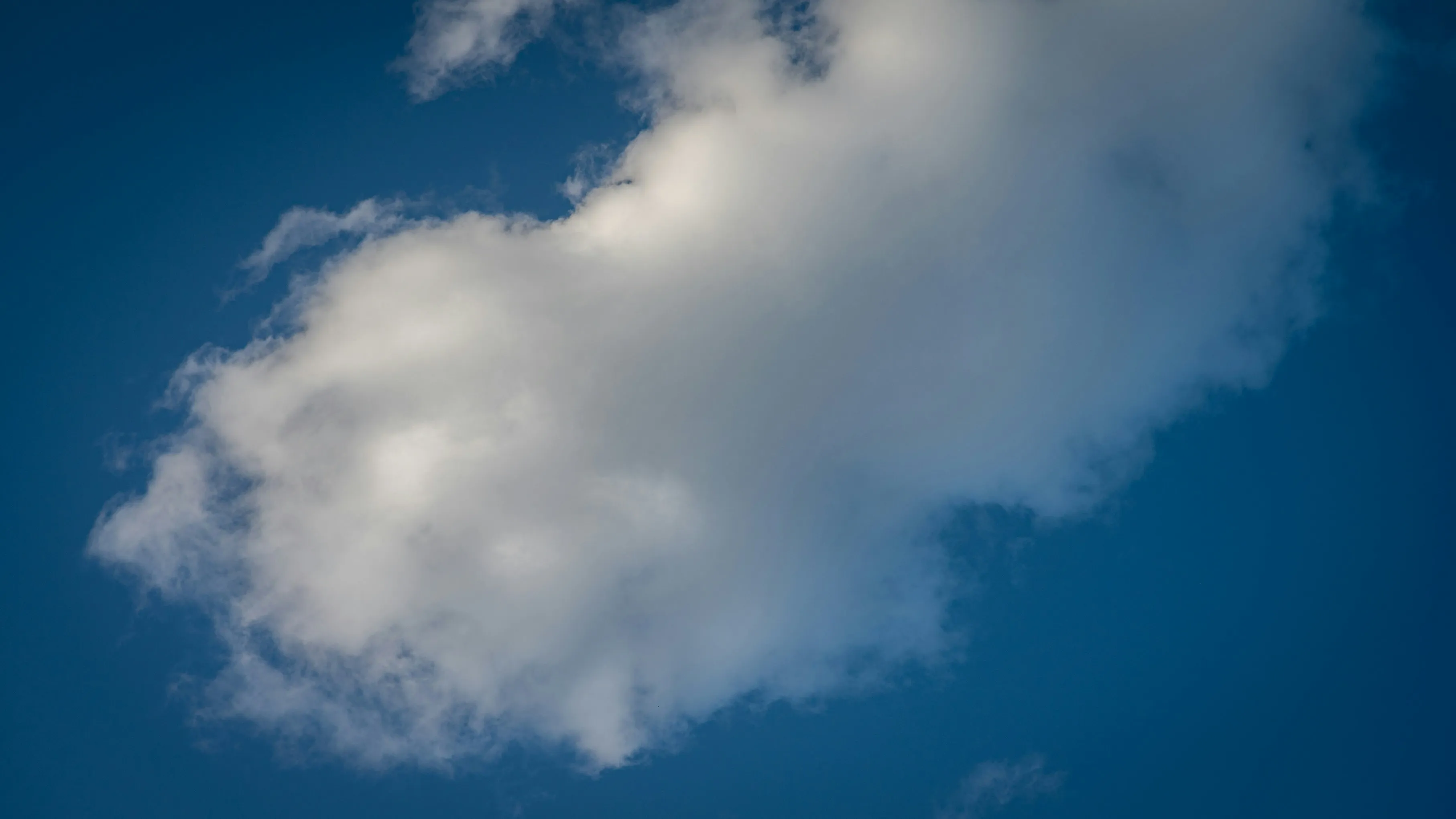 Single Large White Cloud Against a Clear Blue Sky Image