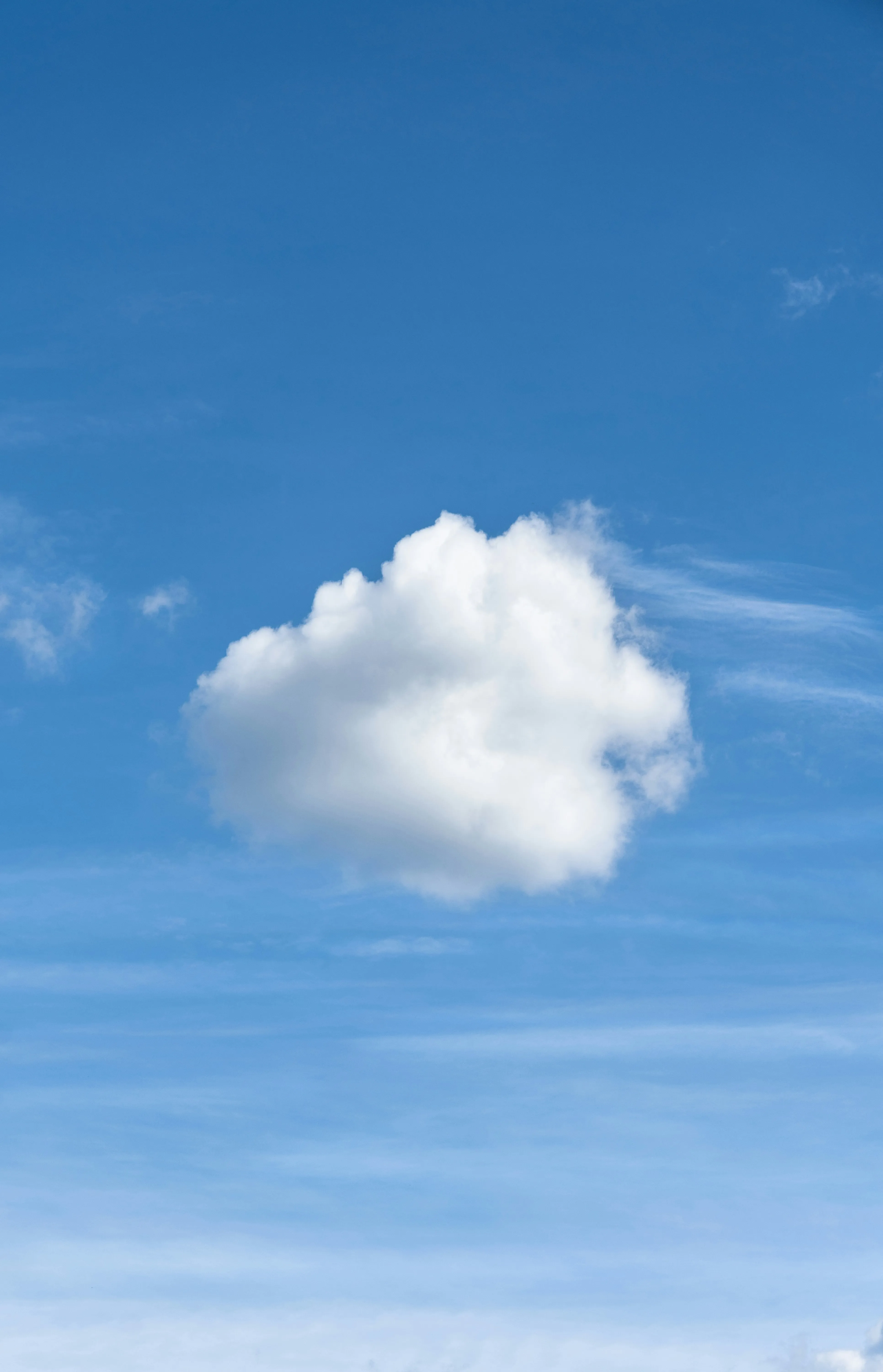 Single White Cloud Floating Against Deep Blue Clear Sky