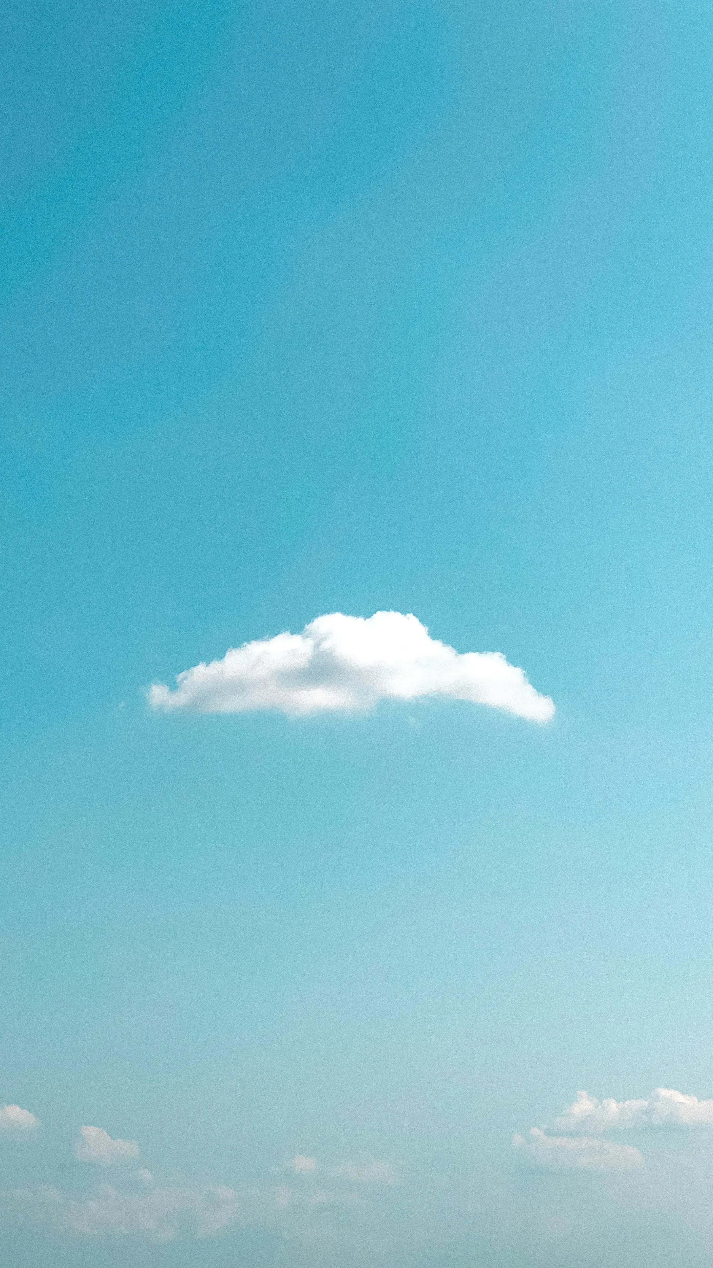Single White Cloud Floating in Bright Blue Clear Sky Scene