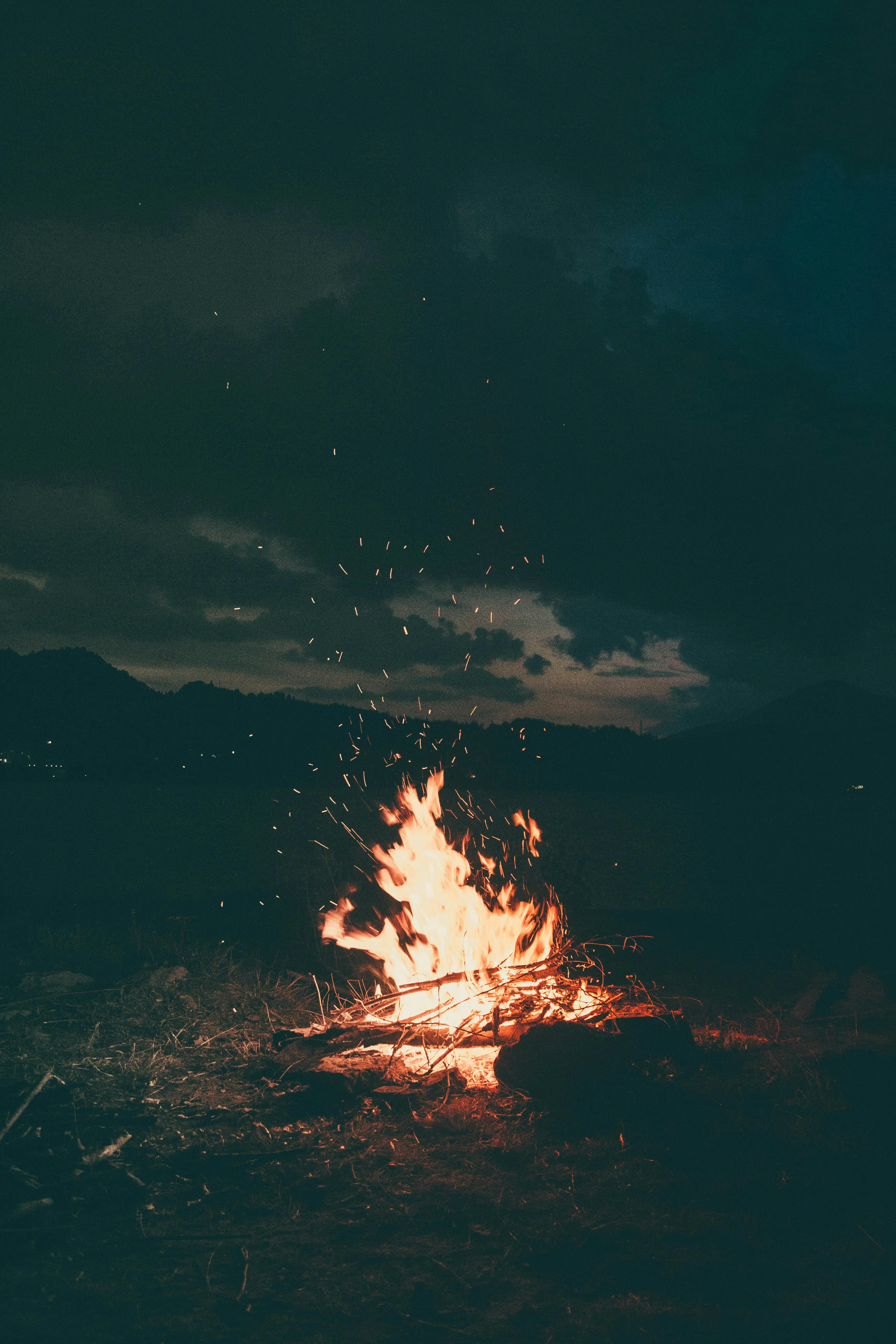 Small Campfire Burning Under a Dark Night Sky 4K Wallpaper
