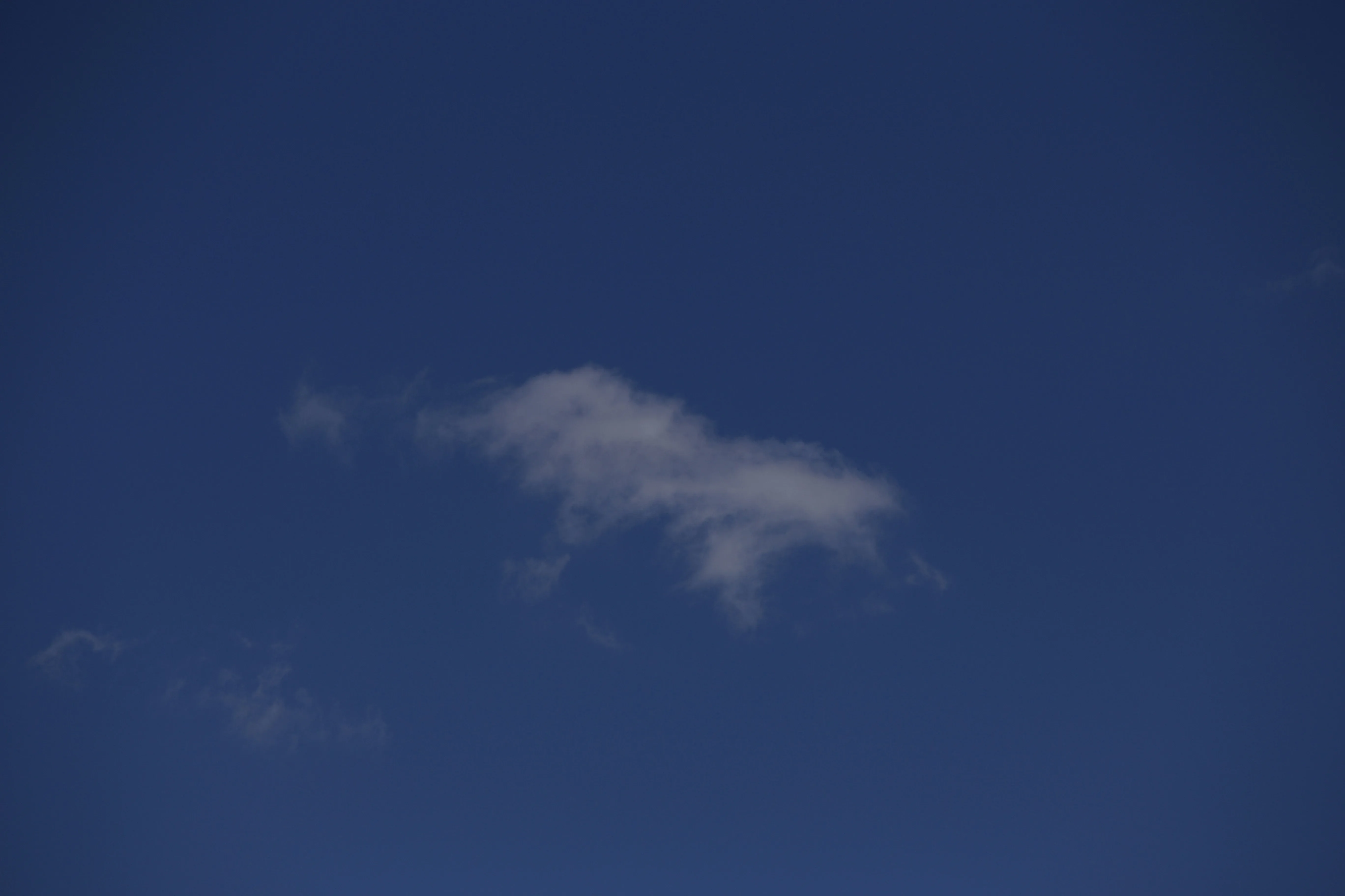 Small Isolated Cloud Floating in Deep Twilight Sky Image