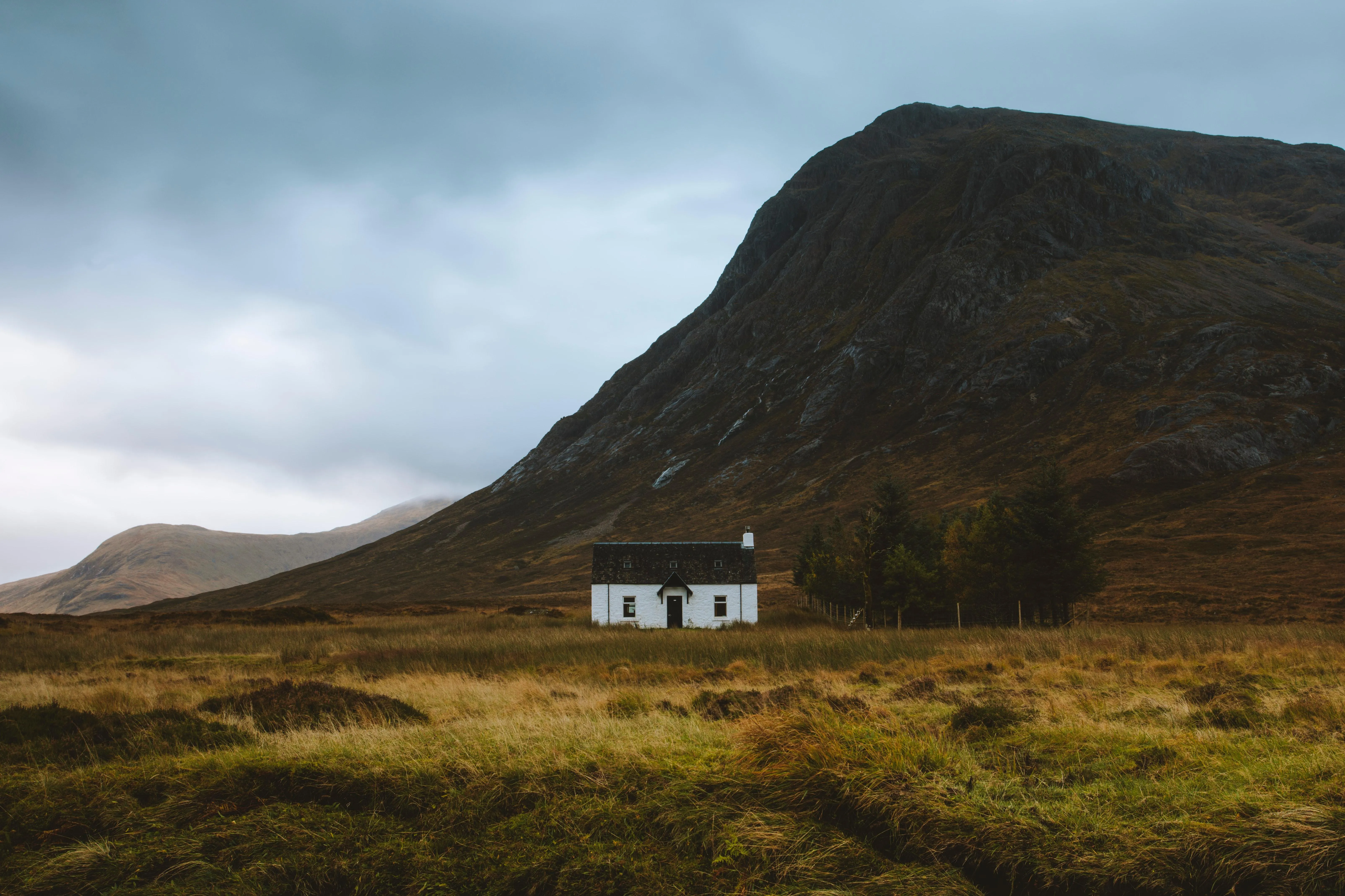 Small White Cottage Set Against a Mountain Backdrop