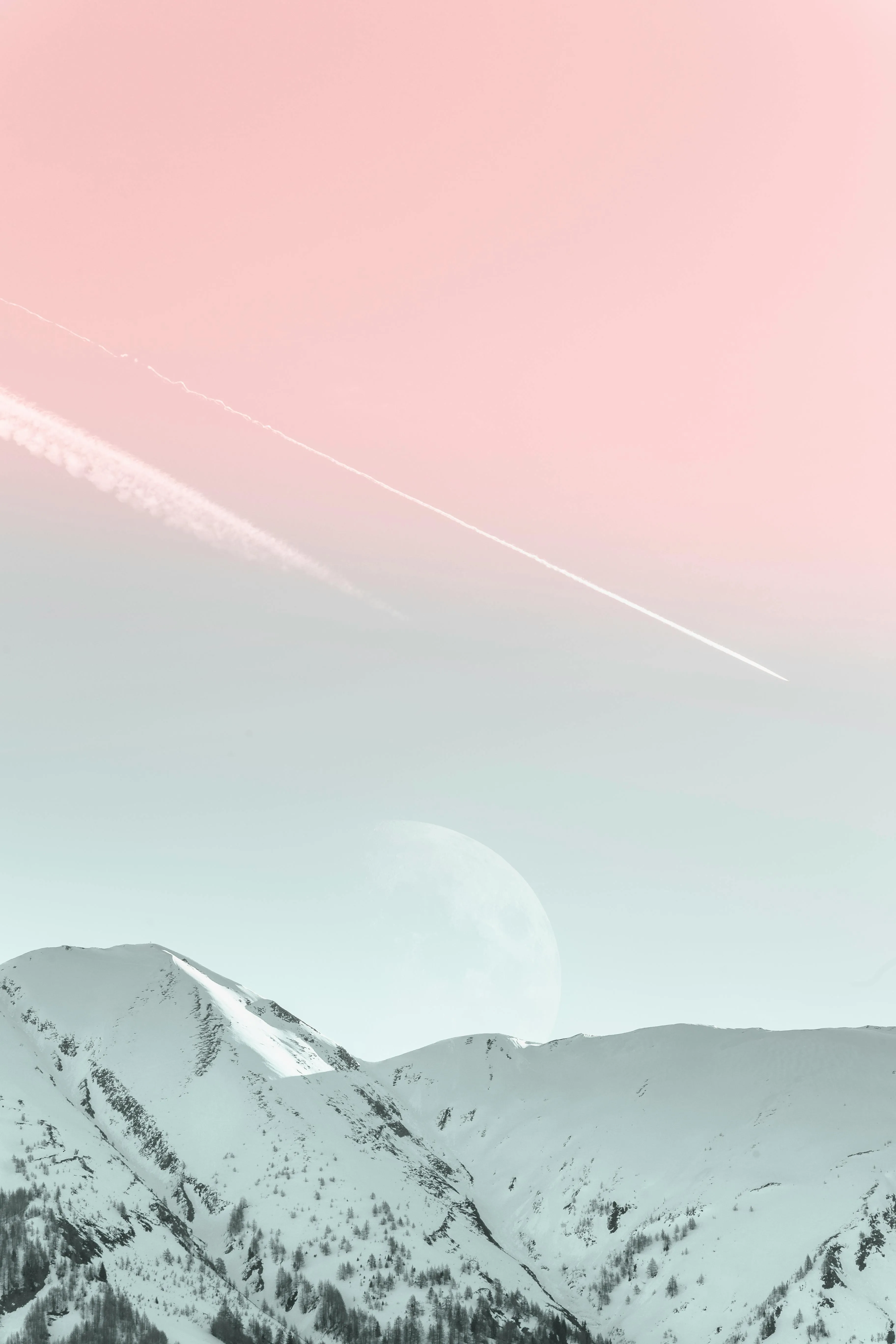 Snow Covered Mountain Peaks Beneath a Soft Pink Sky