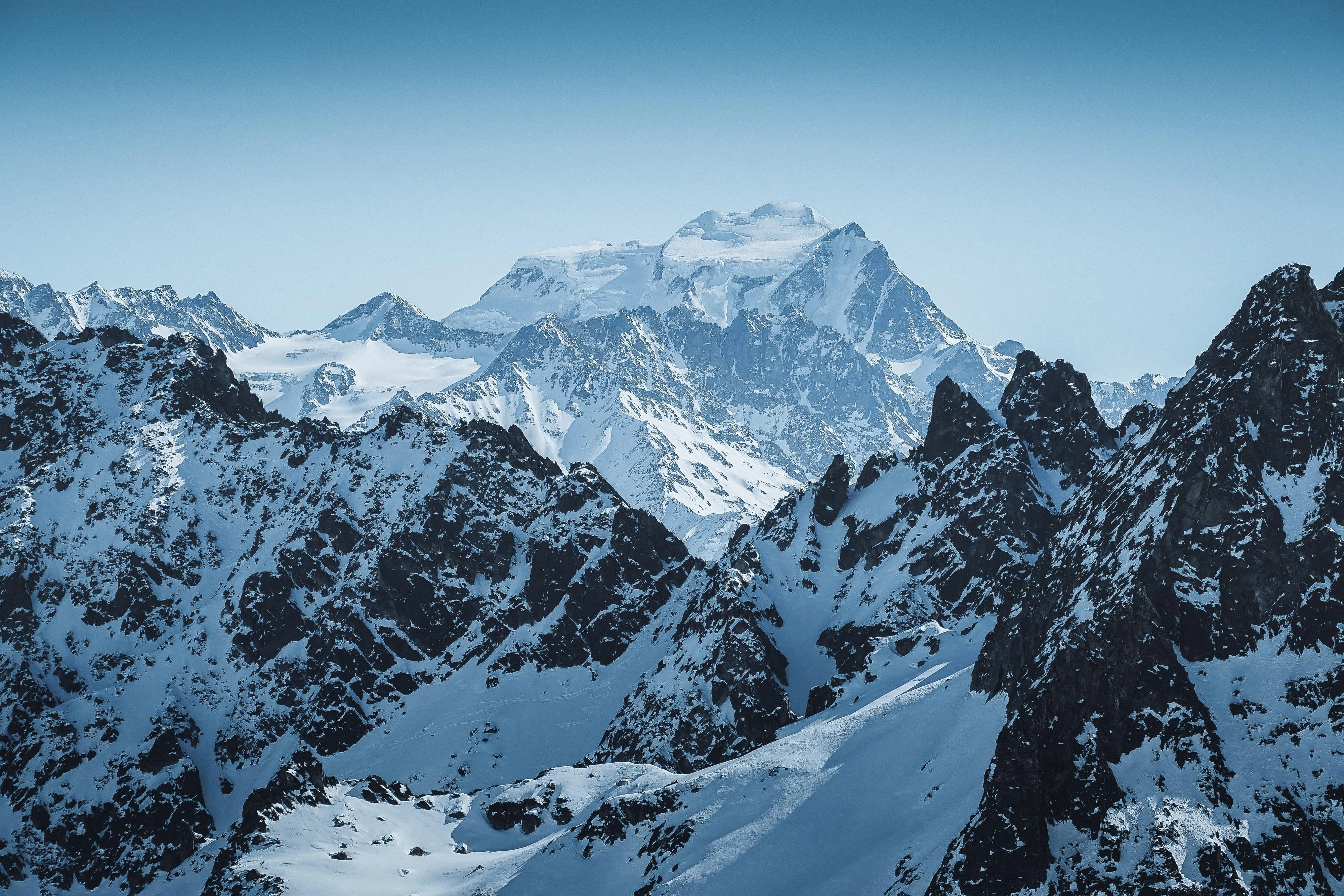 SnowCovered Mountain Peaks Under Blue Sky Wallpaper