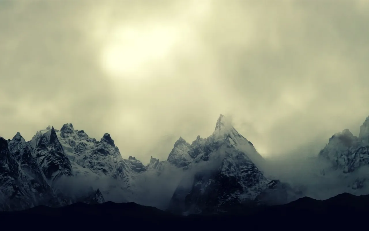 Snowy Mountain Peaks Covered with Thick Clouds Image