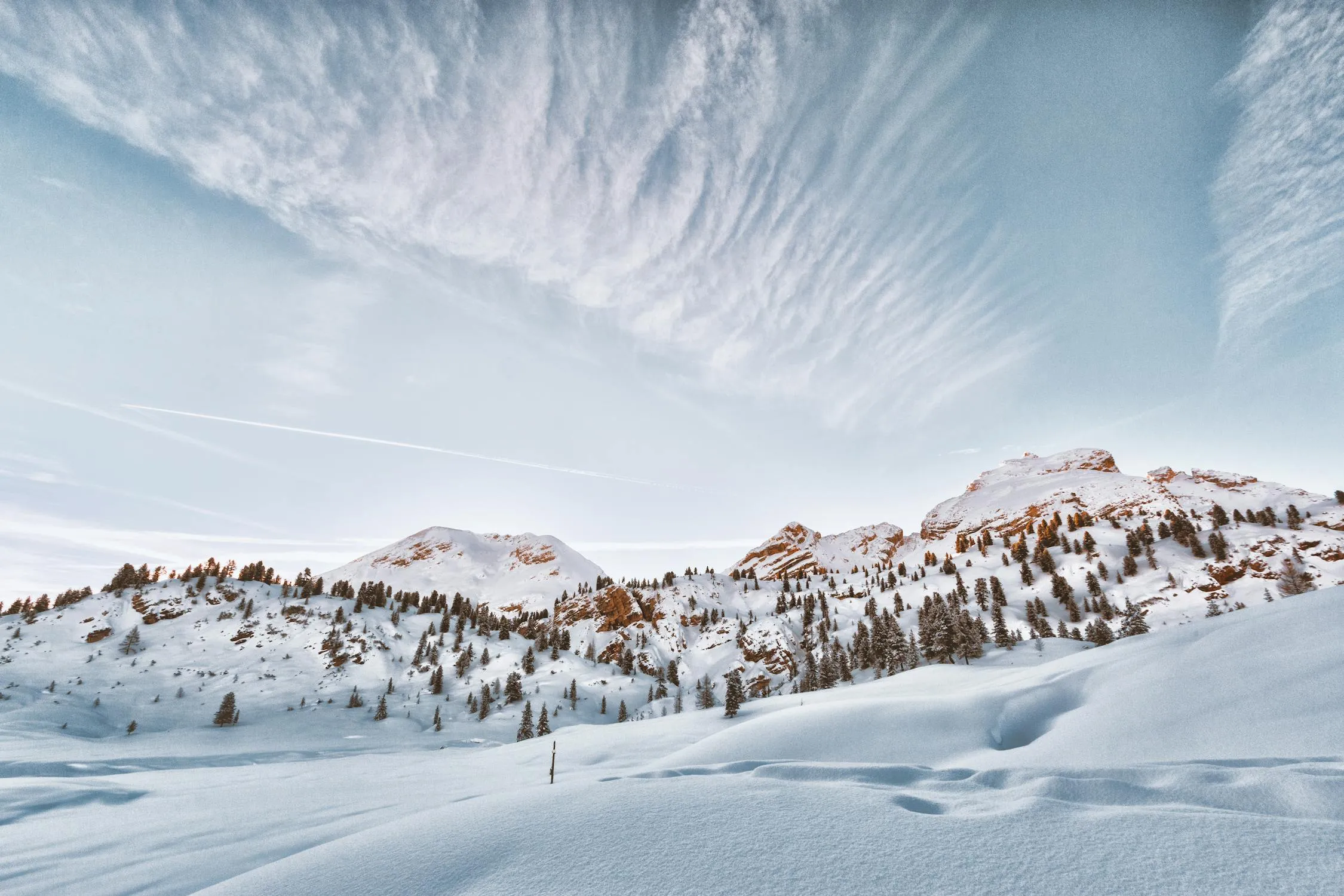 Snowy Mountains Framed By Clear Winter Clouds Wallpaper