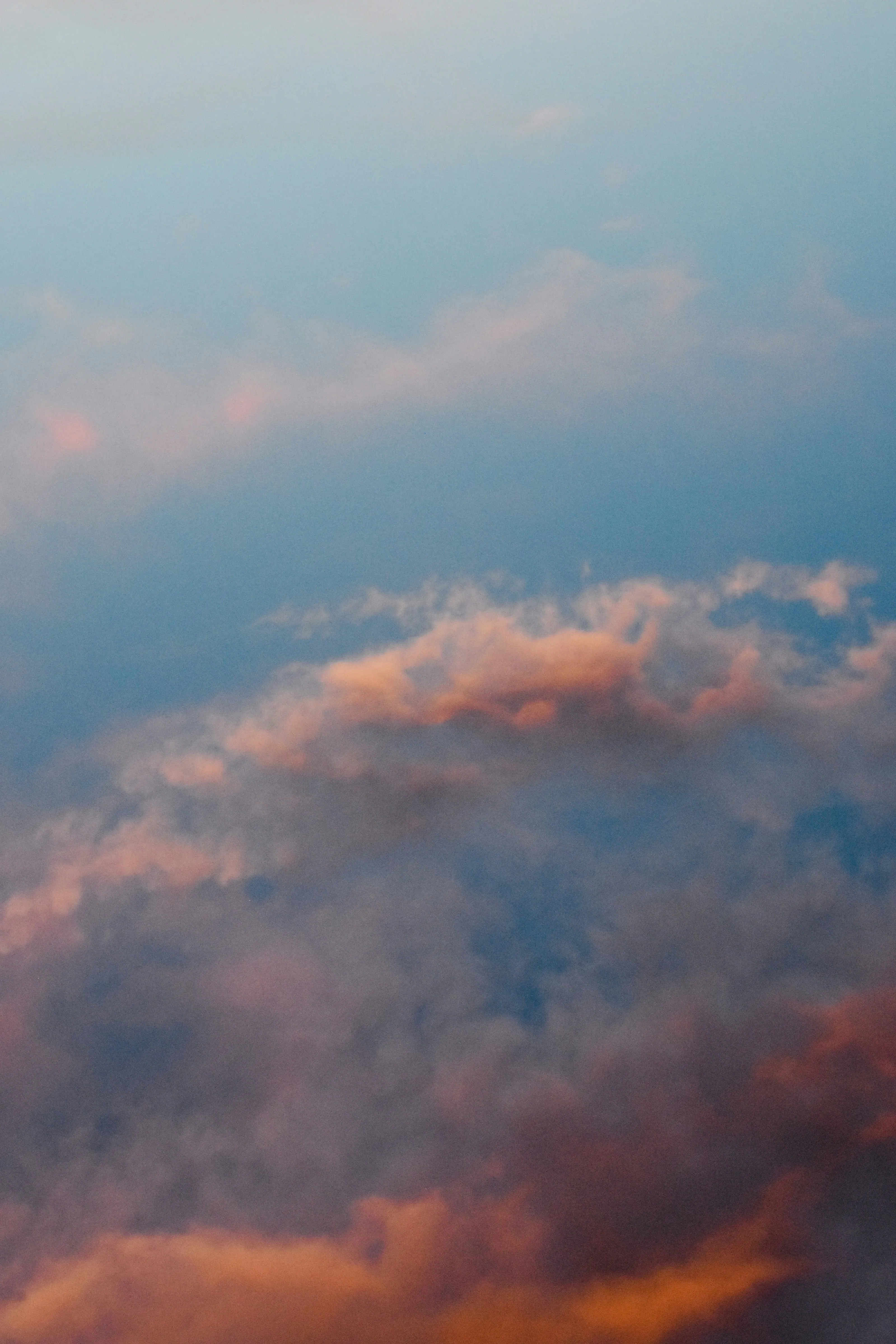 Soft Clouds Reflecting Warm Colors Over a Calm Body of Water