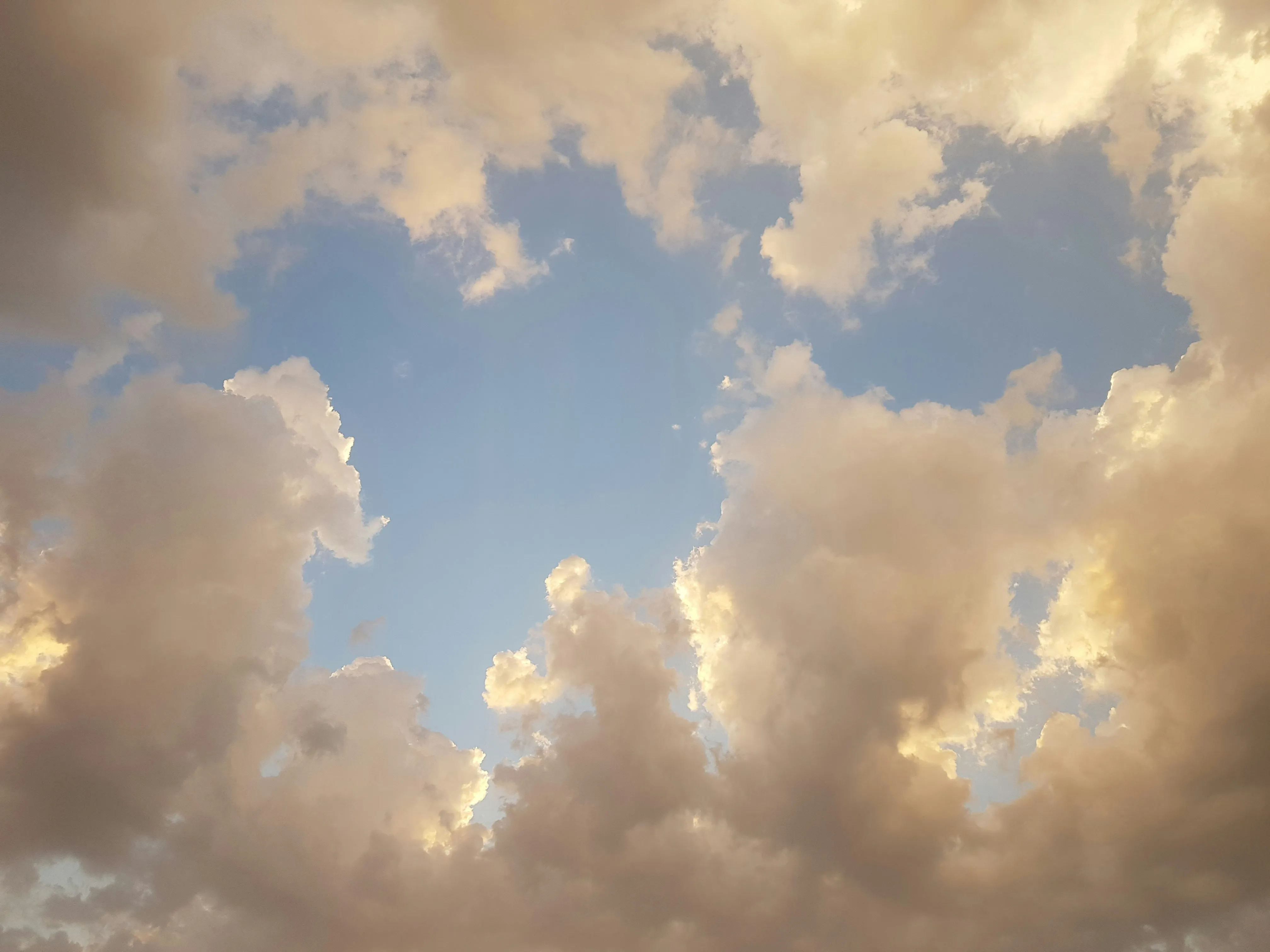 Soft Golden Clouds Floating in a Bright Blue Sky Wallpaper