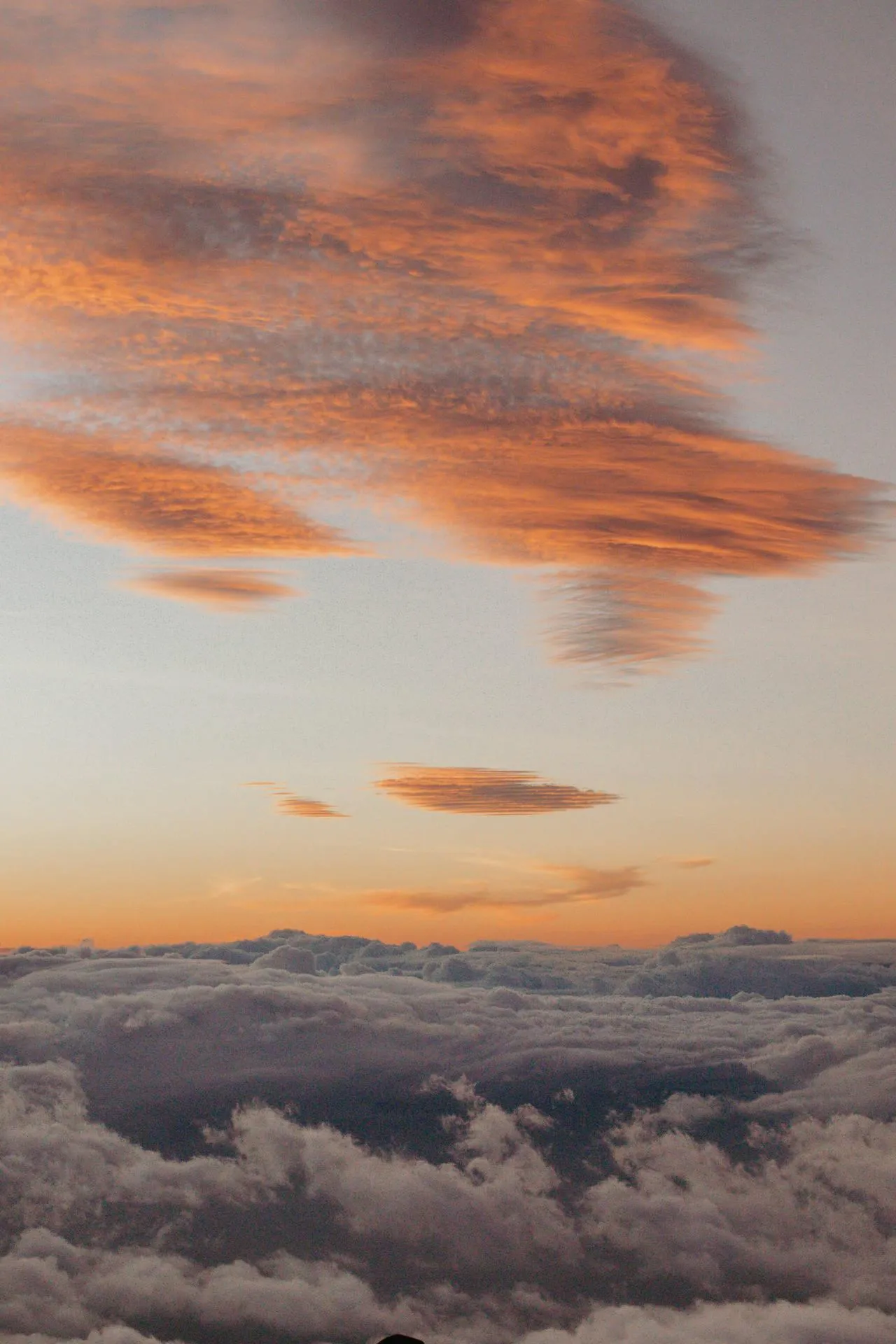 Soft Orange Clouds Above Thick White Clouds in Blue Sky