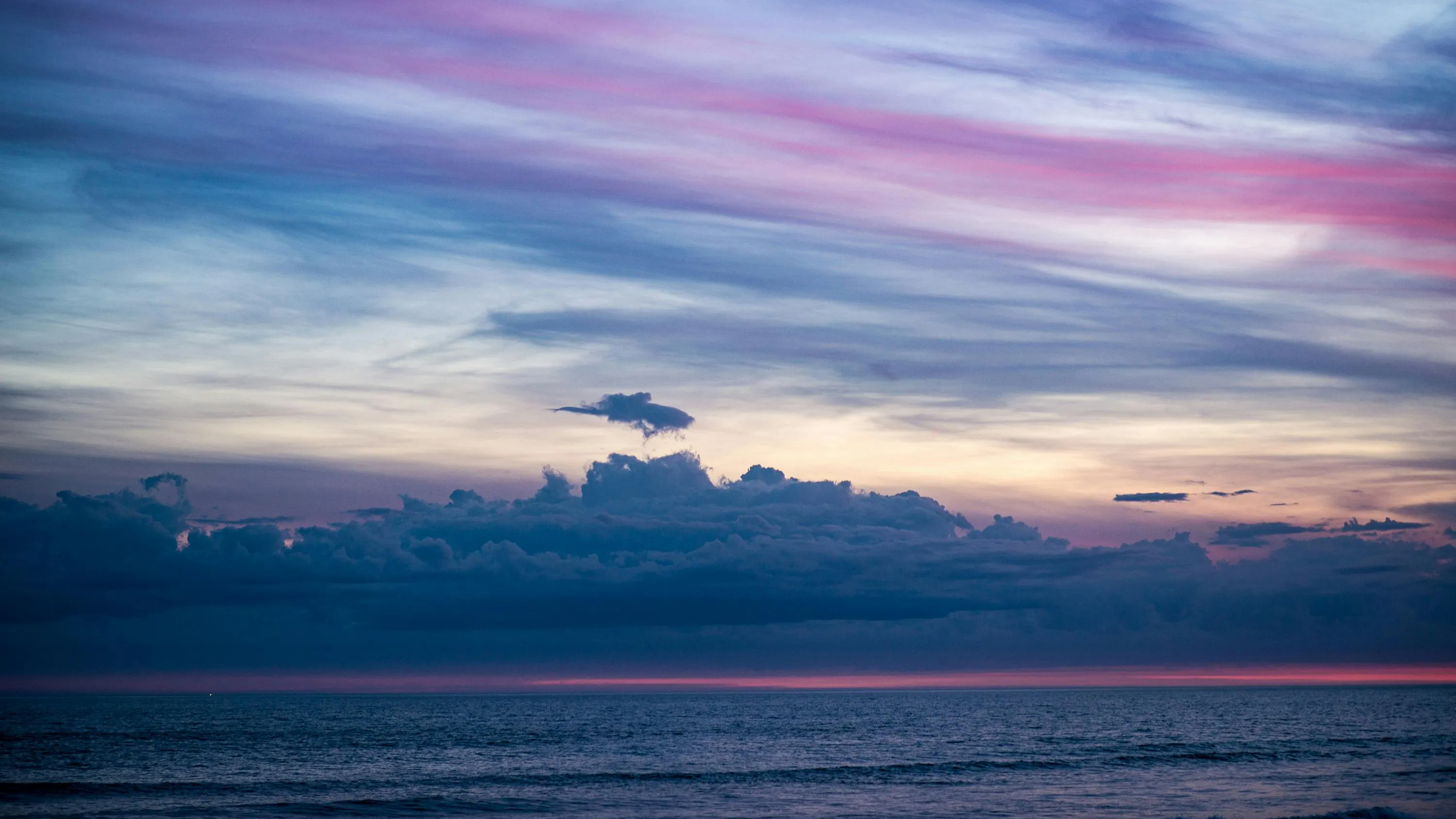 Soft Sunset Over Ocean with Layers of Pink Clouds Image