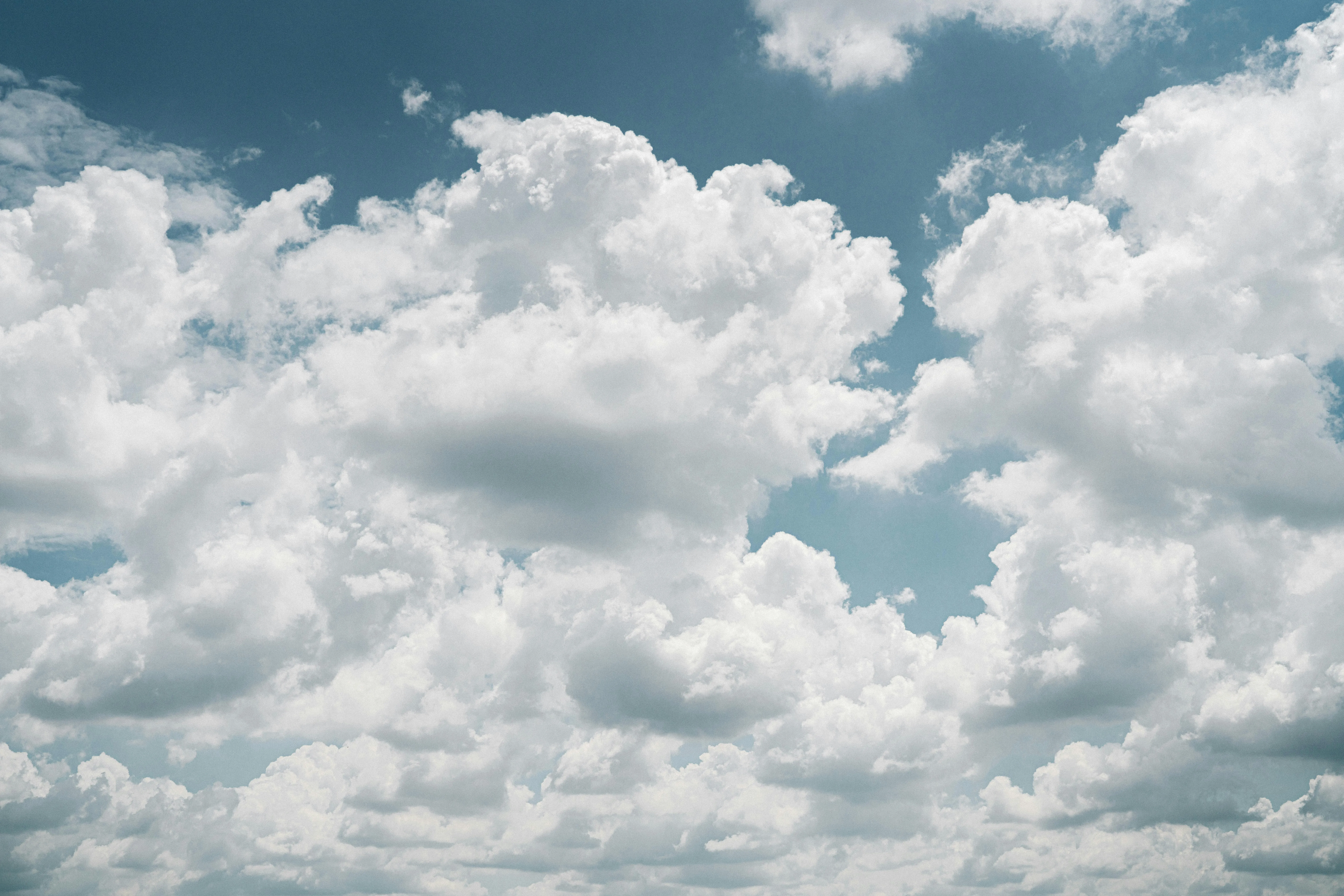 Soft White Clouds Floating in a Blue Sunny Sky Wallpaper