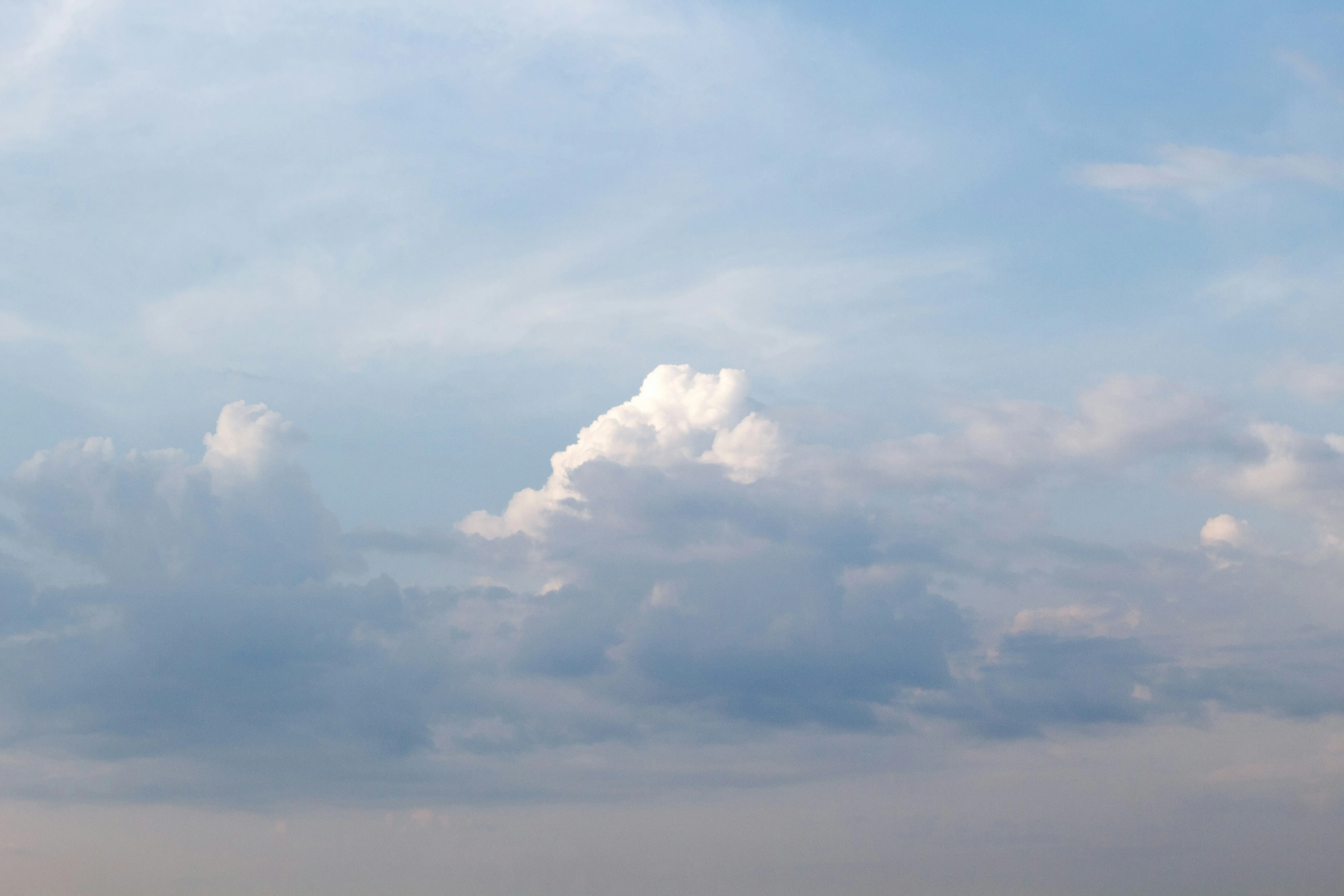Soft White Clouds Floating in a Light Blue Sky Above