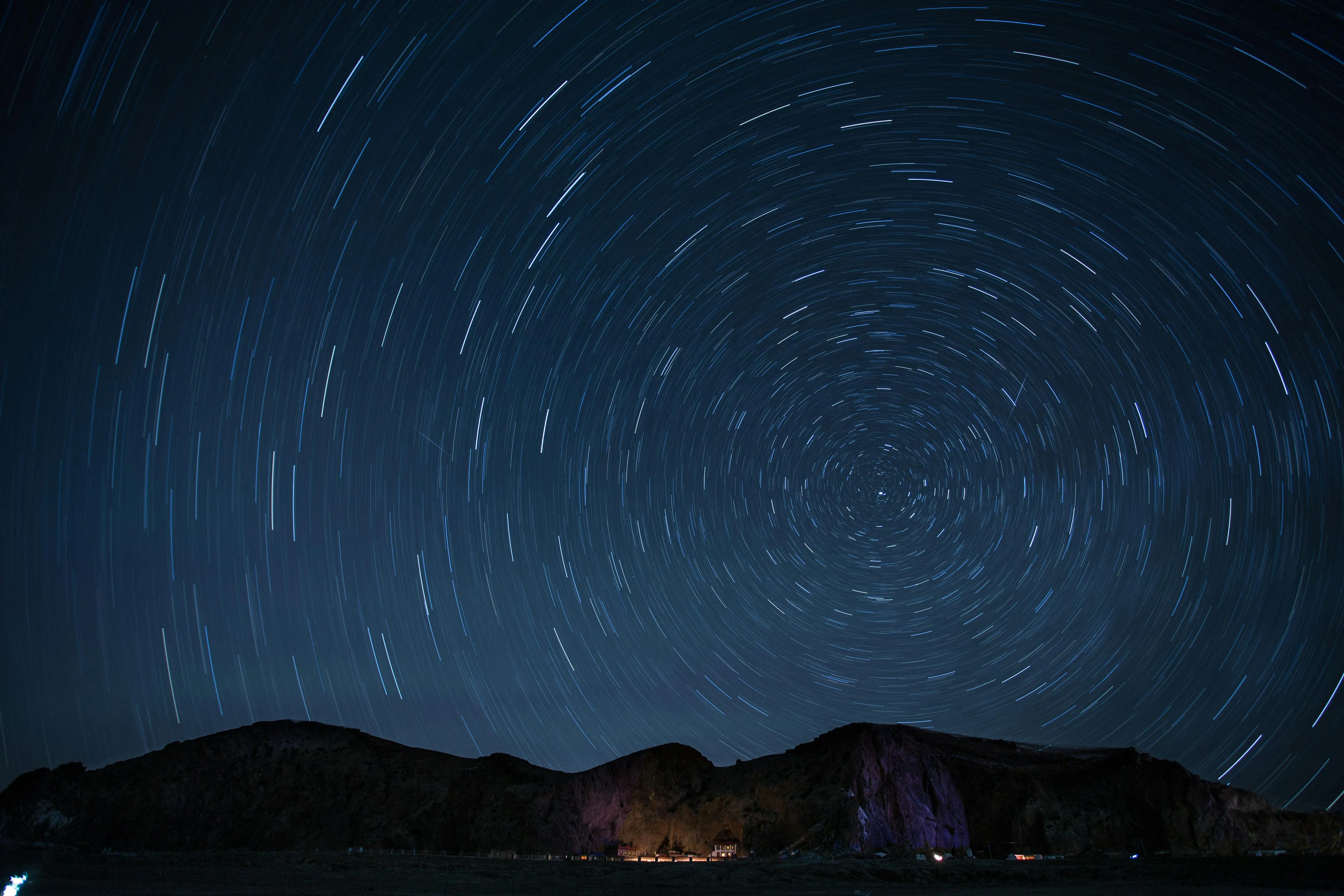 Star Trails Swirling Over Dark Mountains on Clear Night