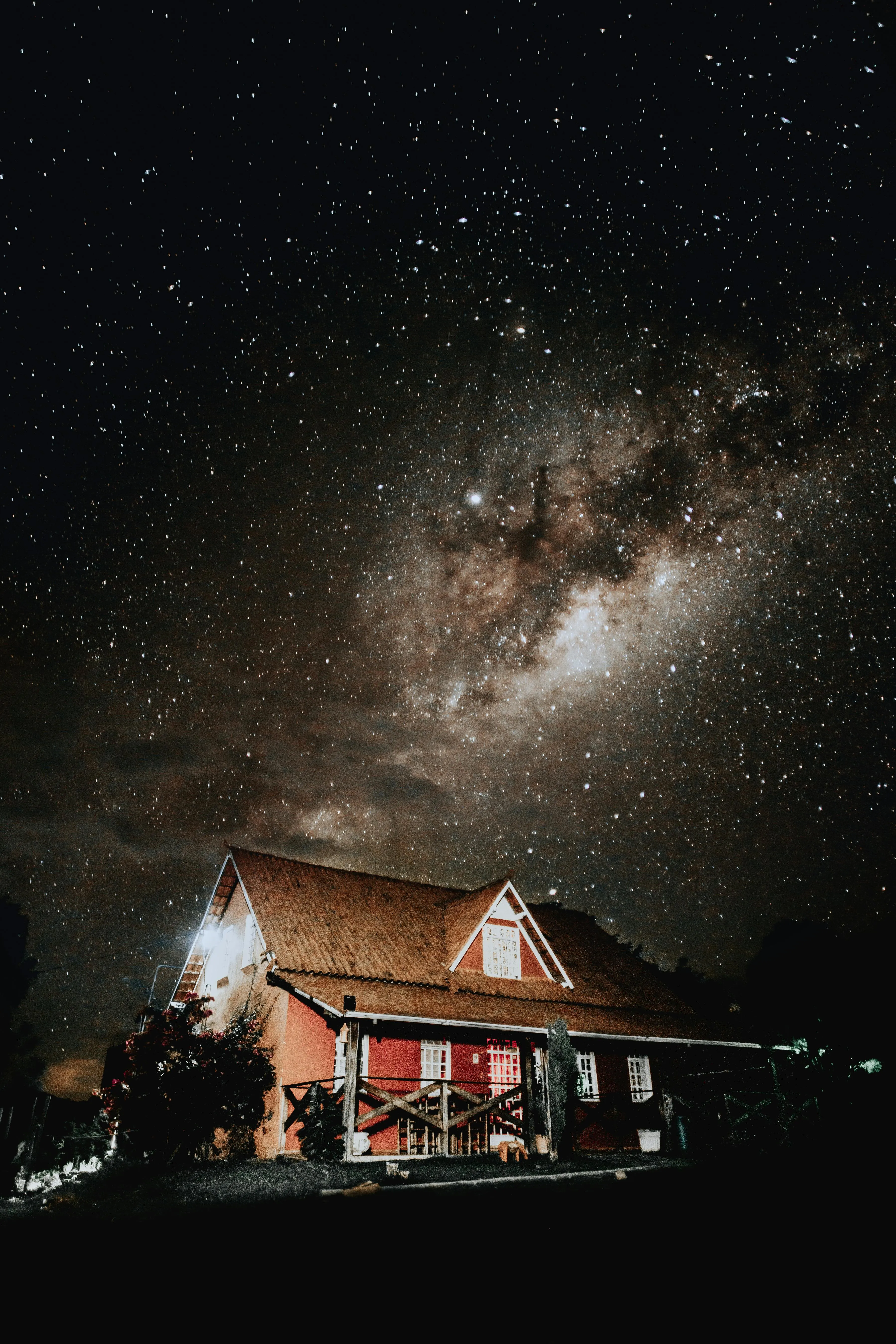 Starry Night Above House with Milky Way and Light Clouds