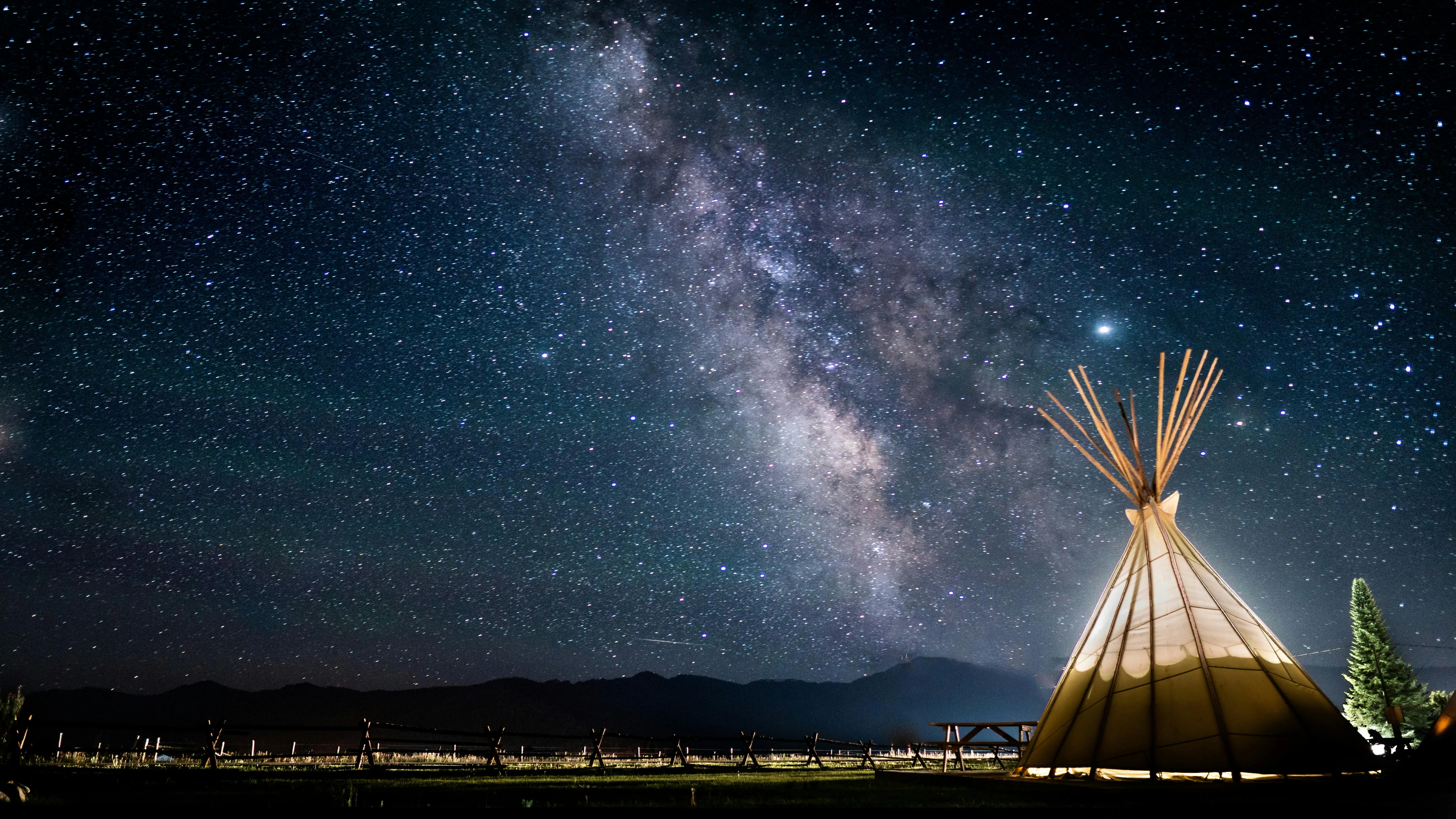Starry Night Sky Above Teepee Tent in Natural Landscape