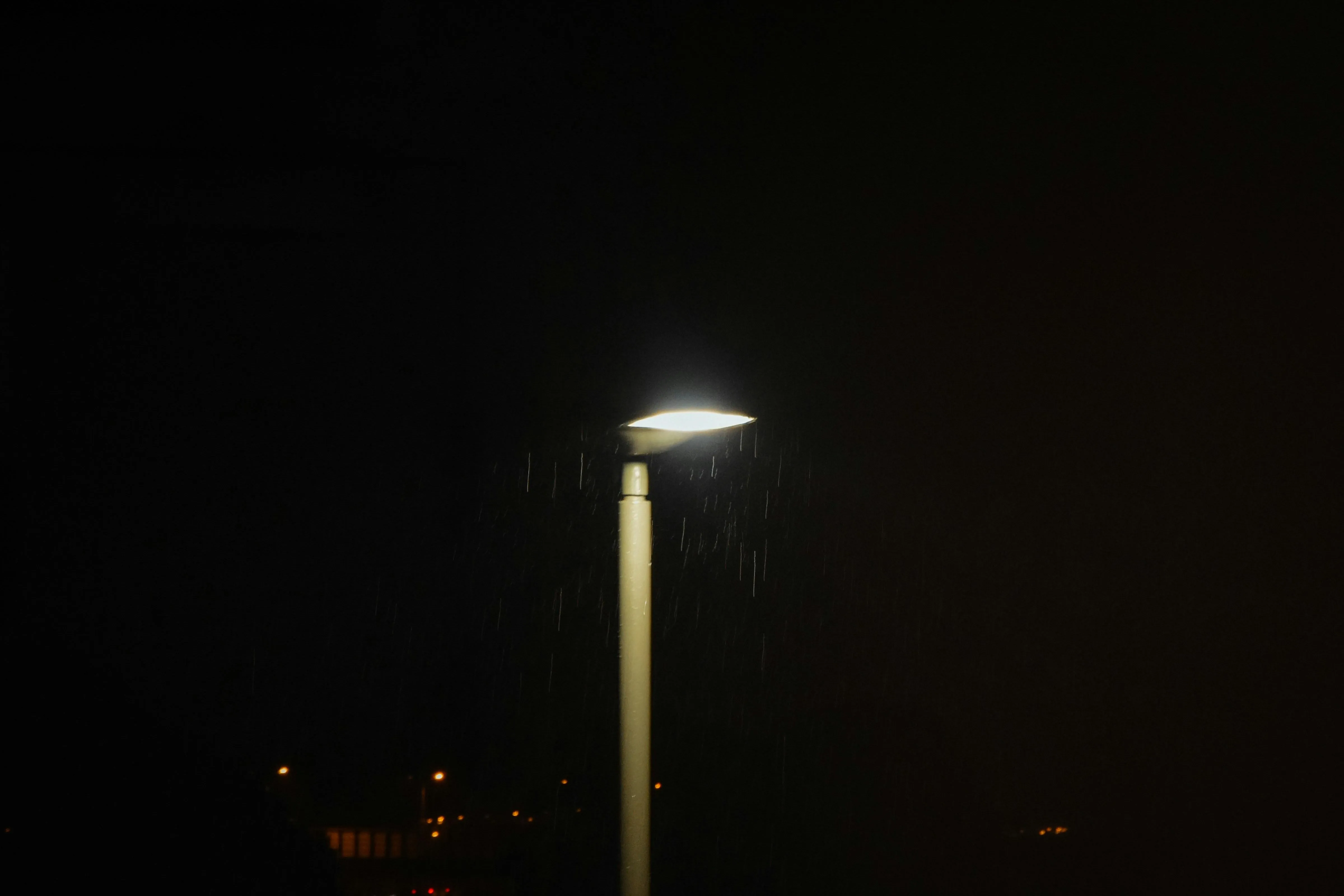 Streetlight Glowing in Dark Rainy Night with Wet Pavement