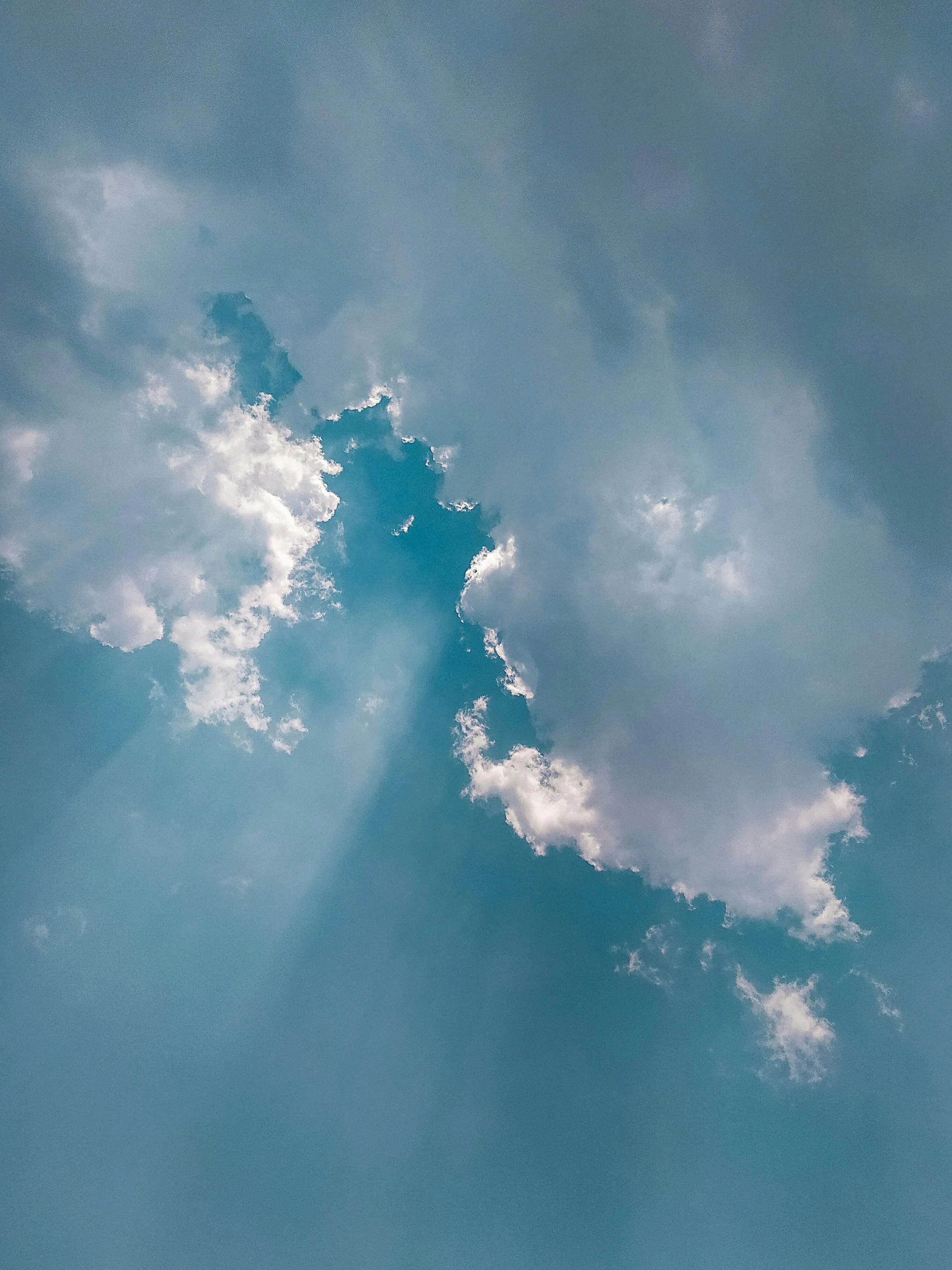 Sun Rays Breaking Through Blue Sky and Scattered Clouds