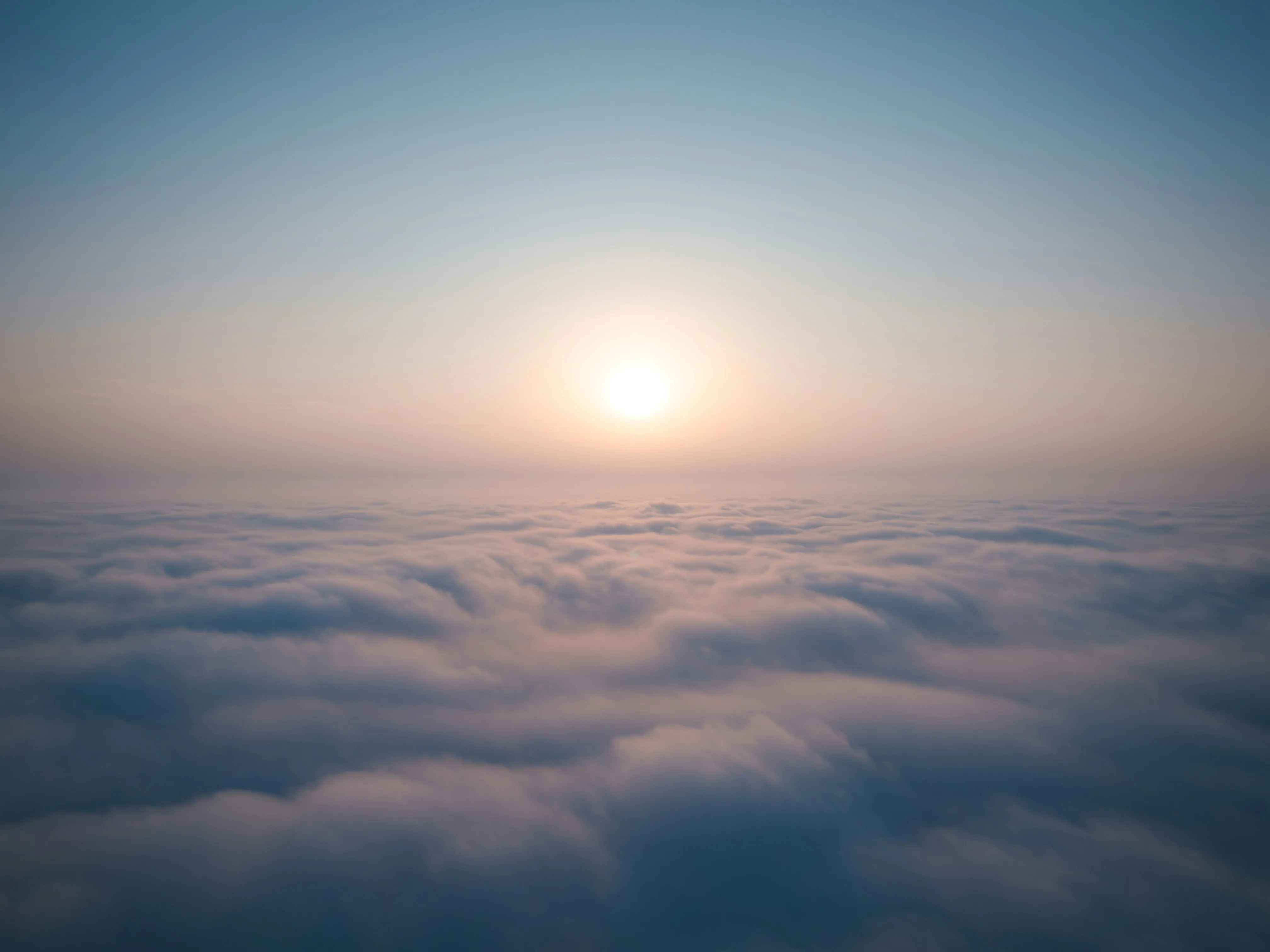 Sun Rising Above a Sea of Clouds in Early Morning Image
