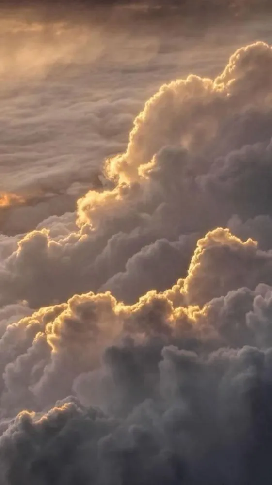 Sunlit Clouds Forming Layers Over a Golden Sky Wallpaper