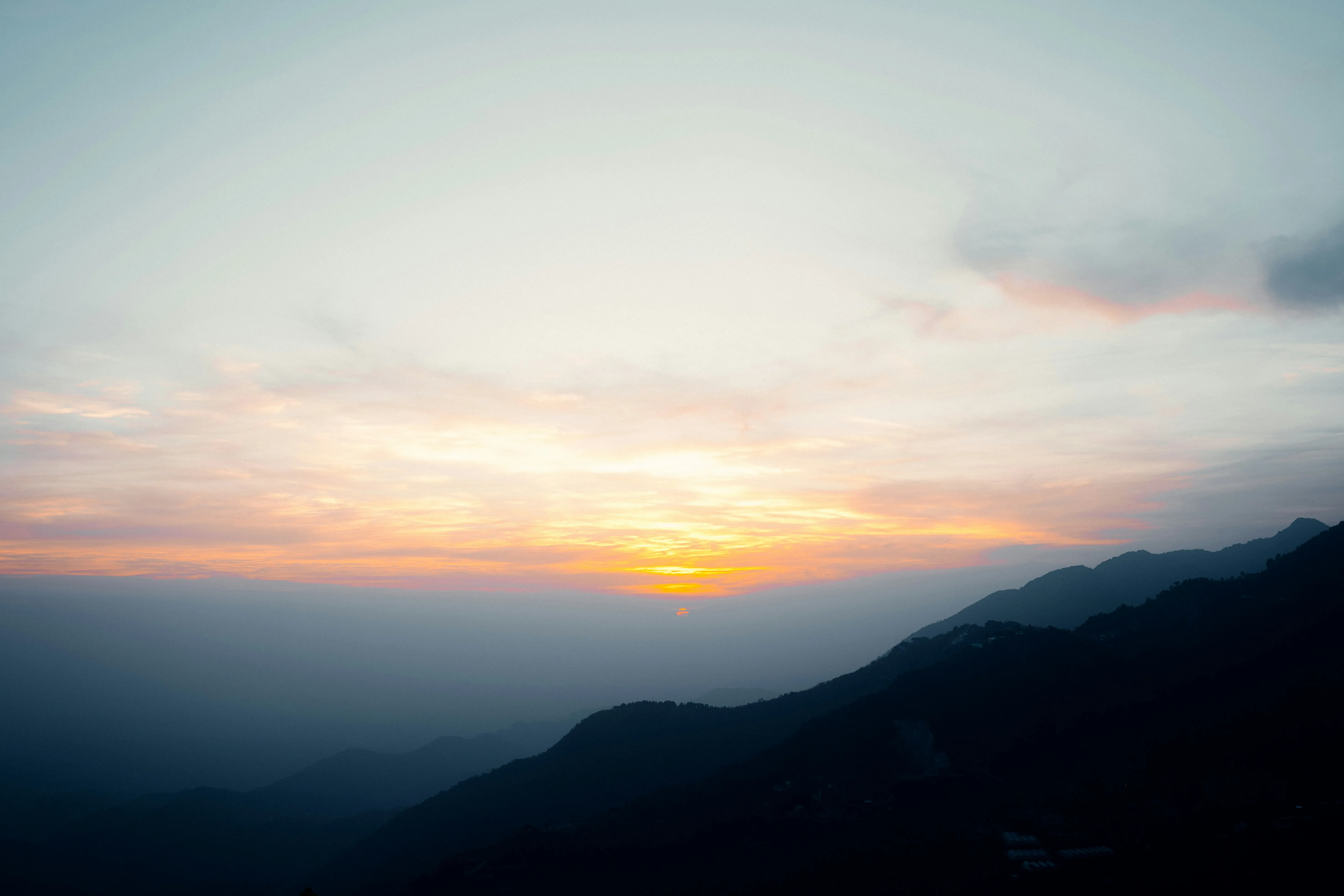 Sunset Behind Mountains Casting Warm Light and Shadows