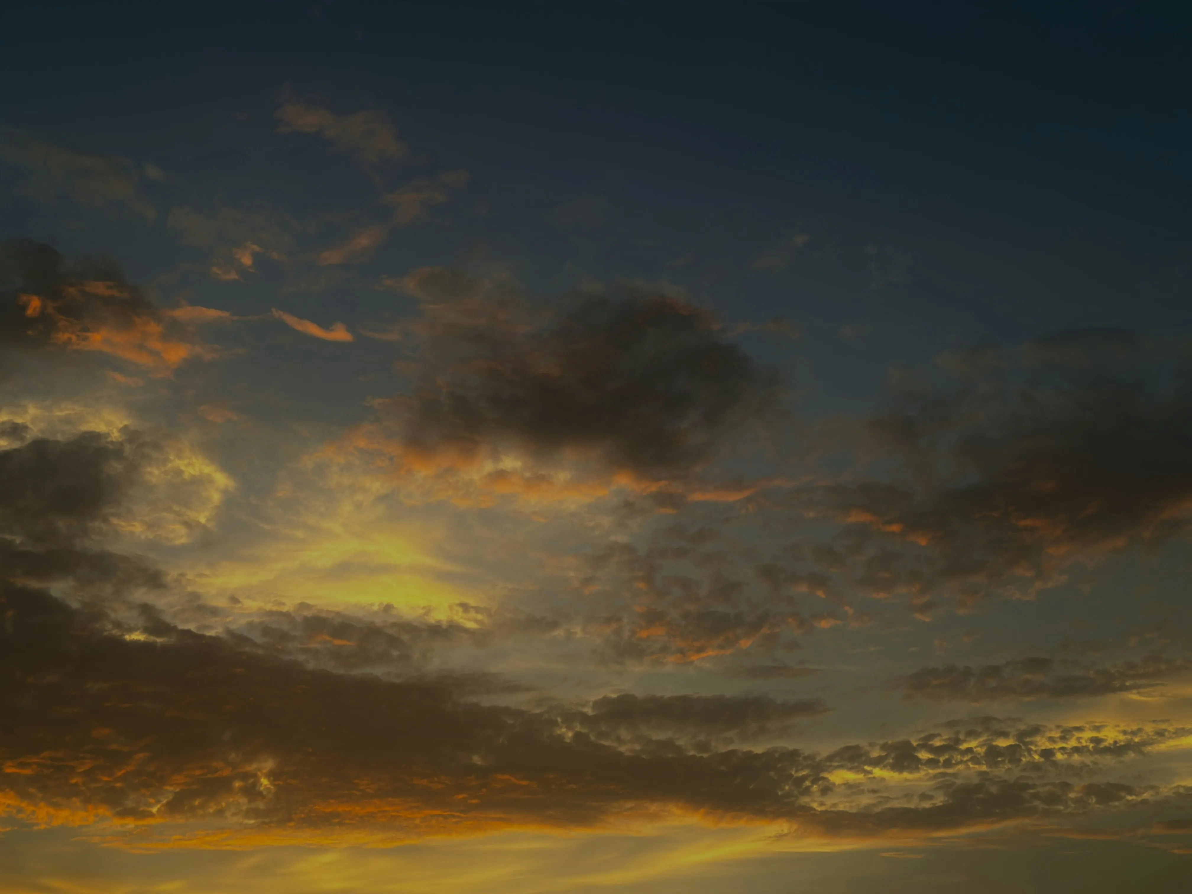 Sunset Lighting Storm Clouds Over Distant Landscape