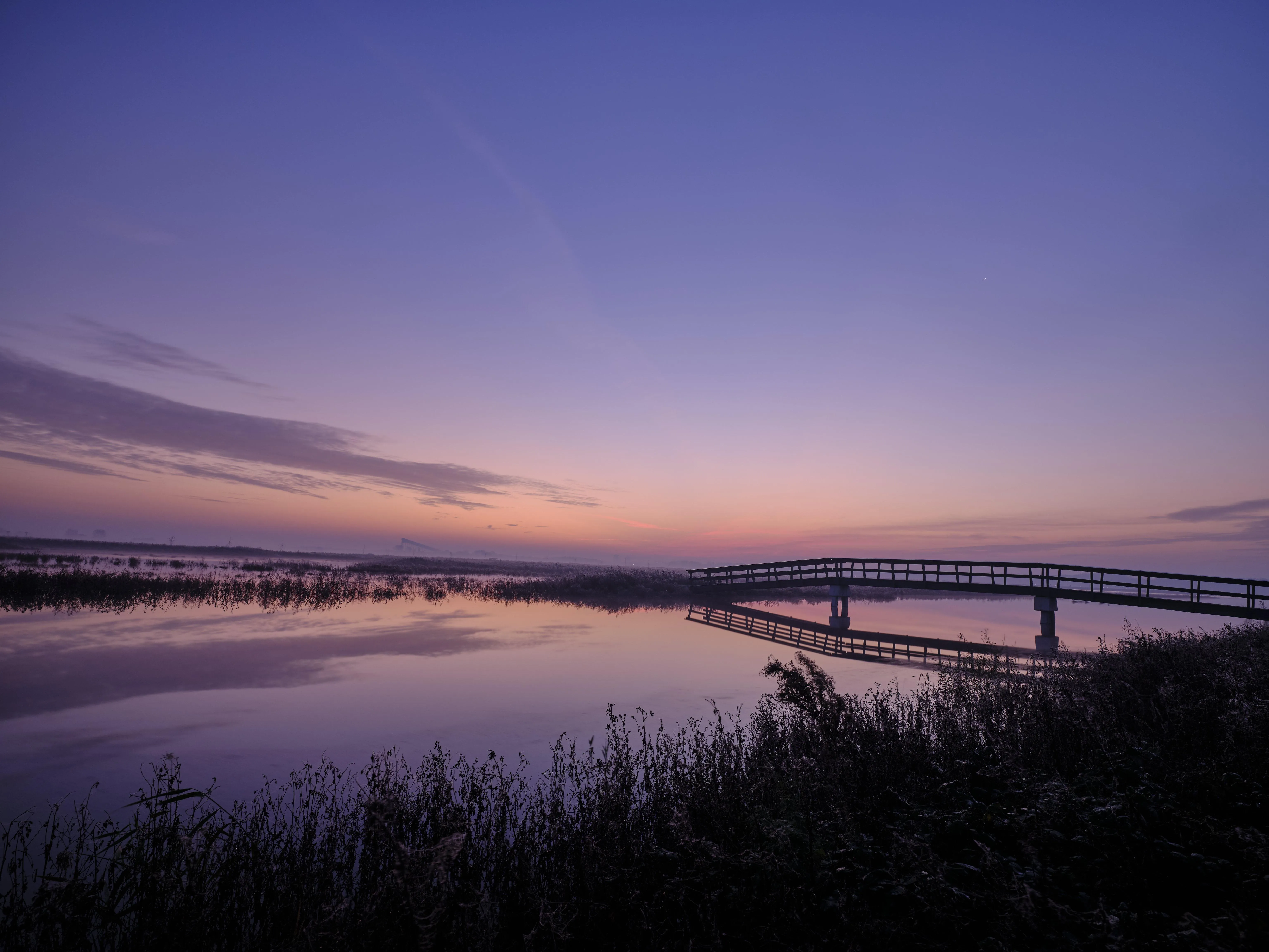 Sunset over ocean bridge with light reflections free HD image