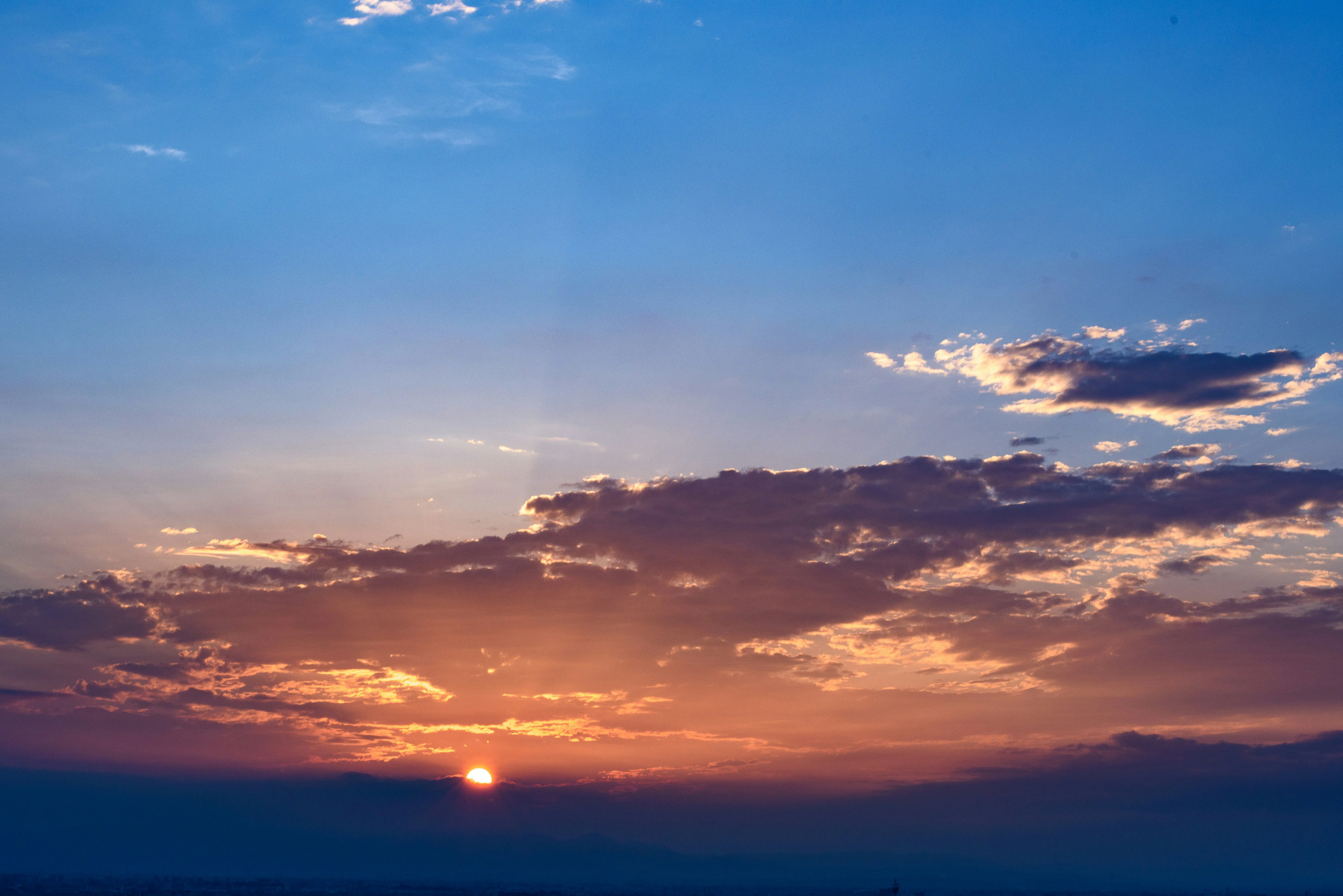 Sunset Over Ocean Horizon with Golden Clouds Wallpaper