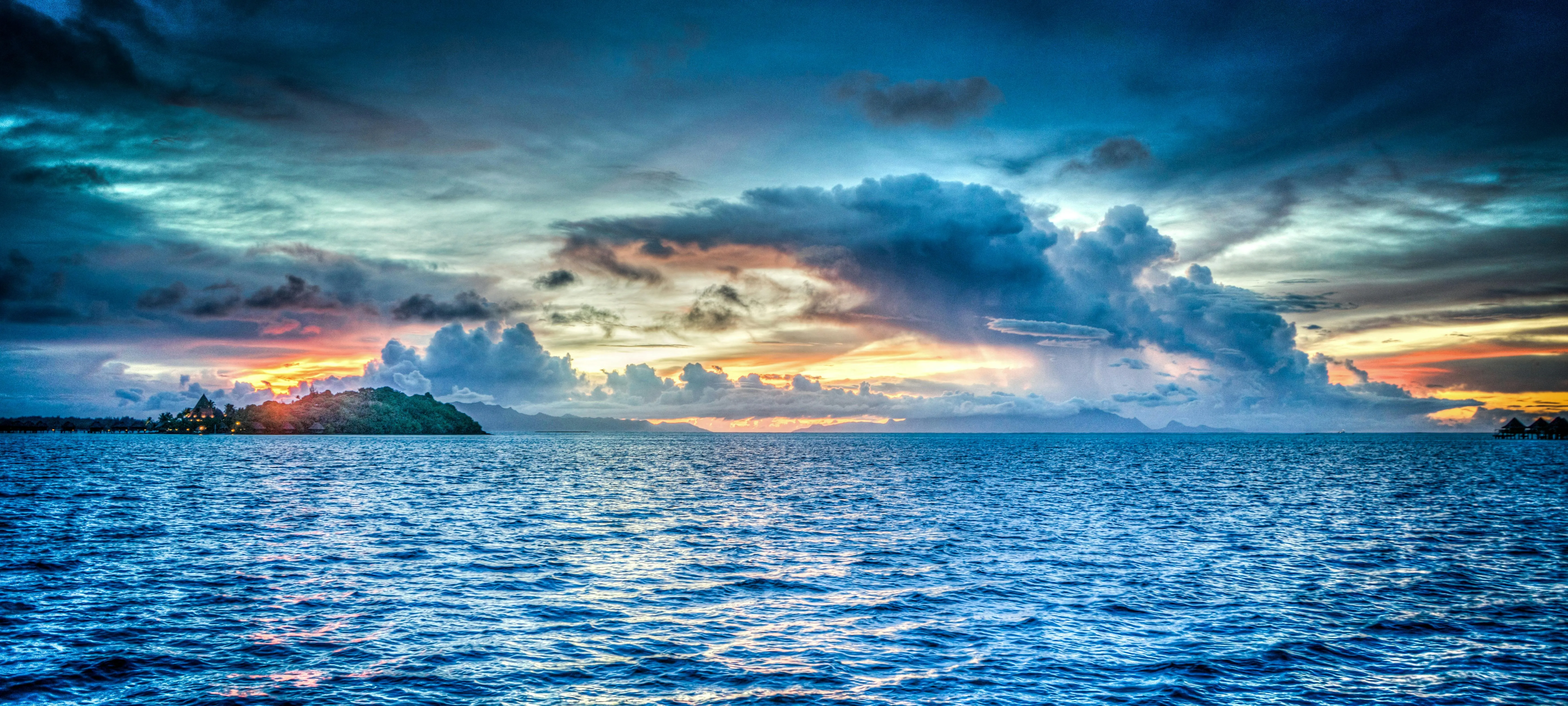 Sunset Over Ocean with Dark Clouds and Bright Horizon