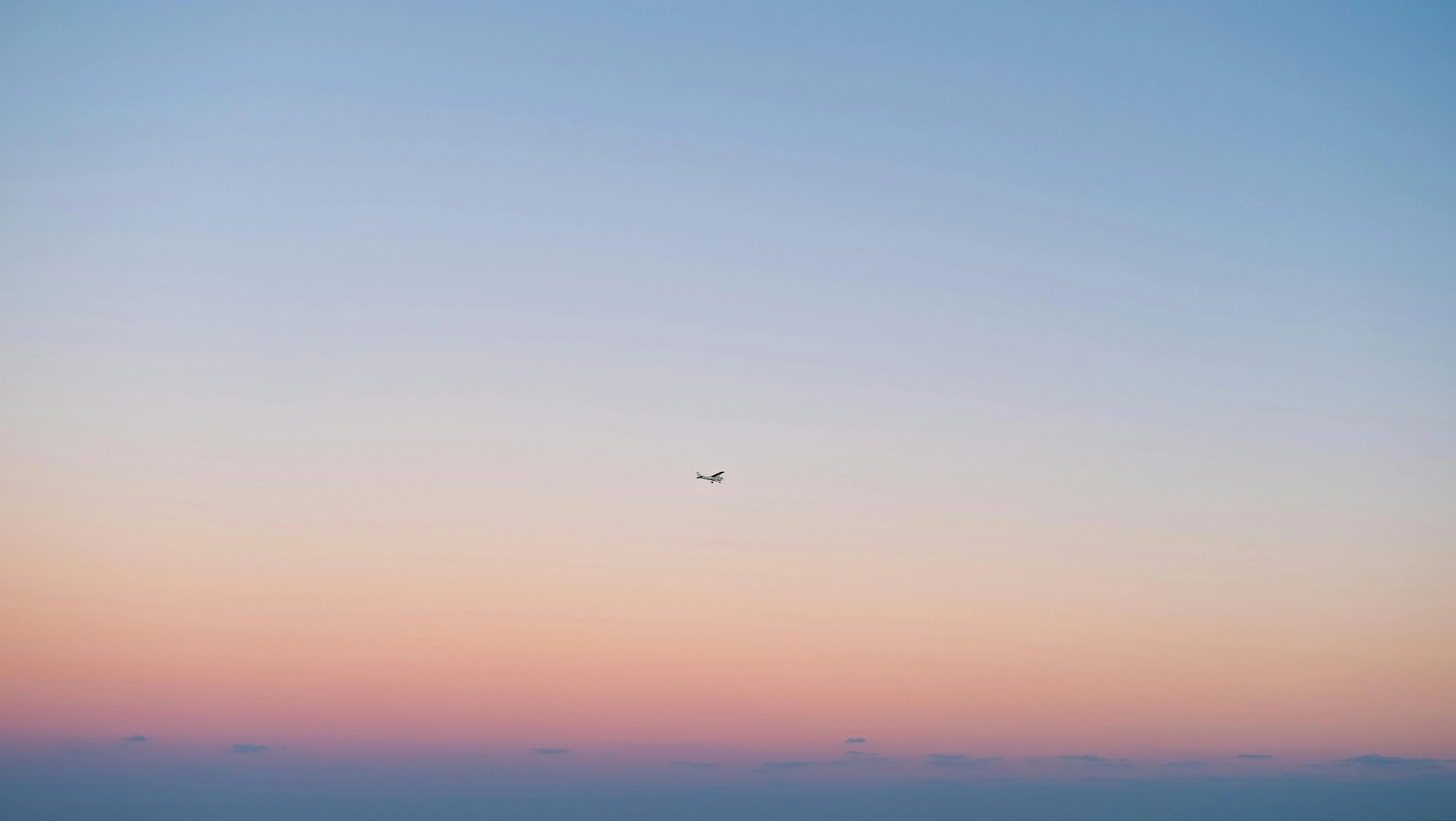Sunset Sky with Fading Light and a Small Plane Flying Wallpaper