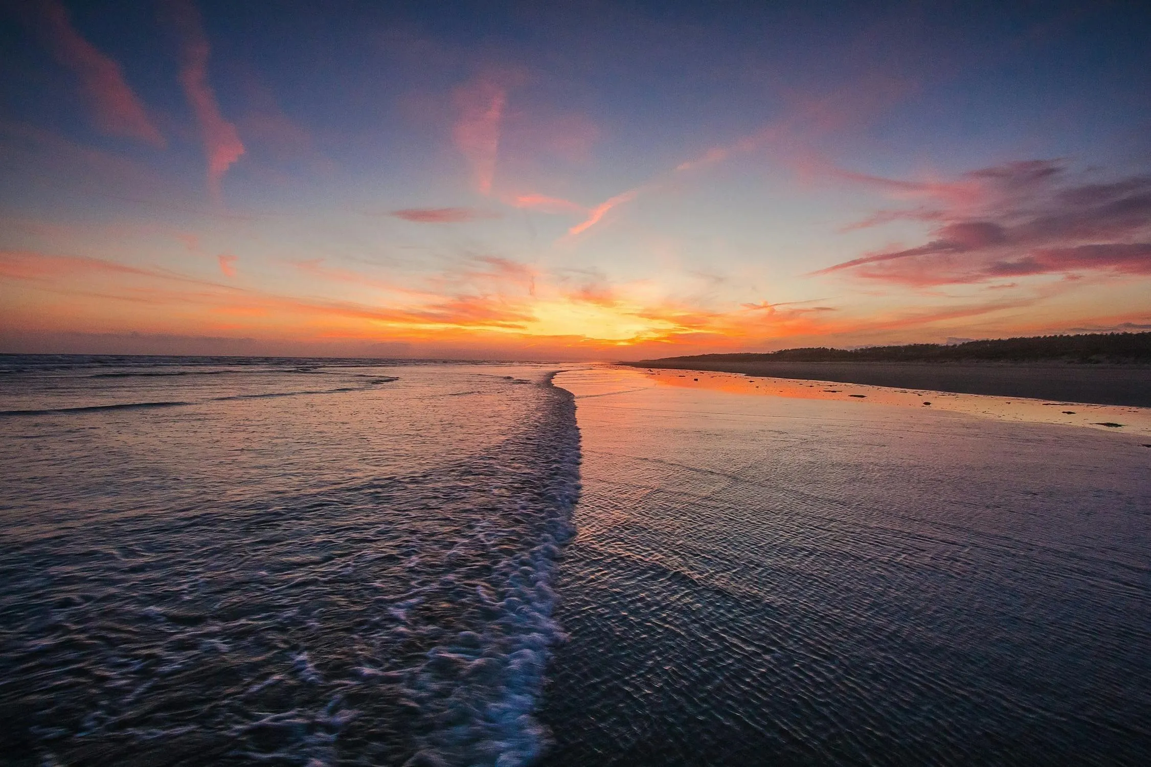 Sunset View Over a Beach with Ocean Waves and Cloudy Sky