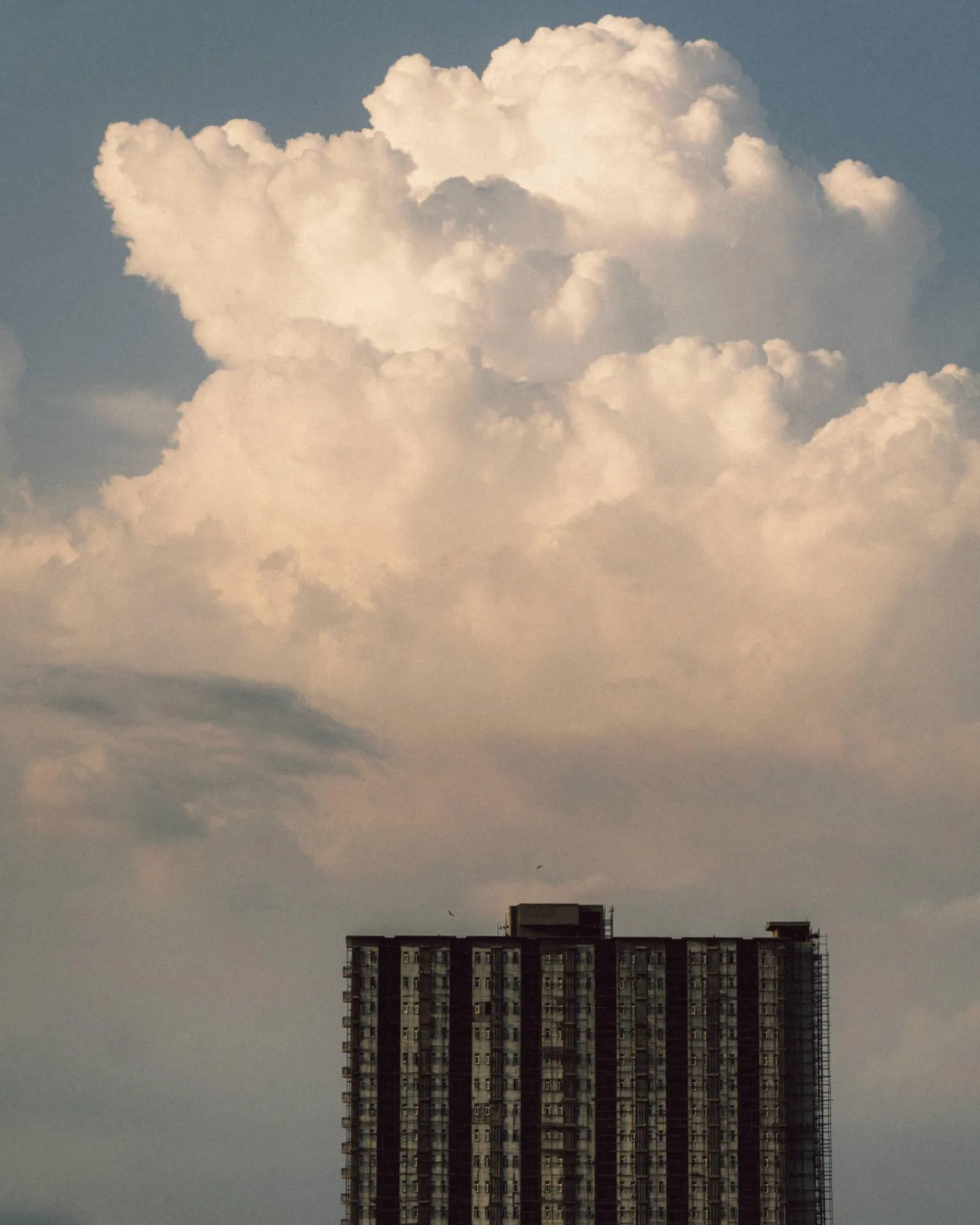 Tall Building Against Large Cloud Formation on Overcast Day