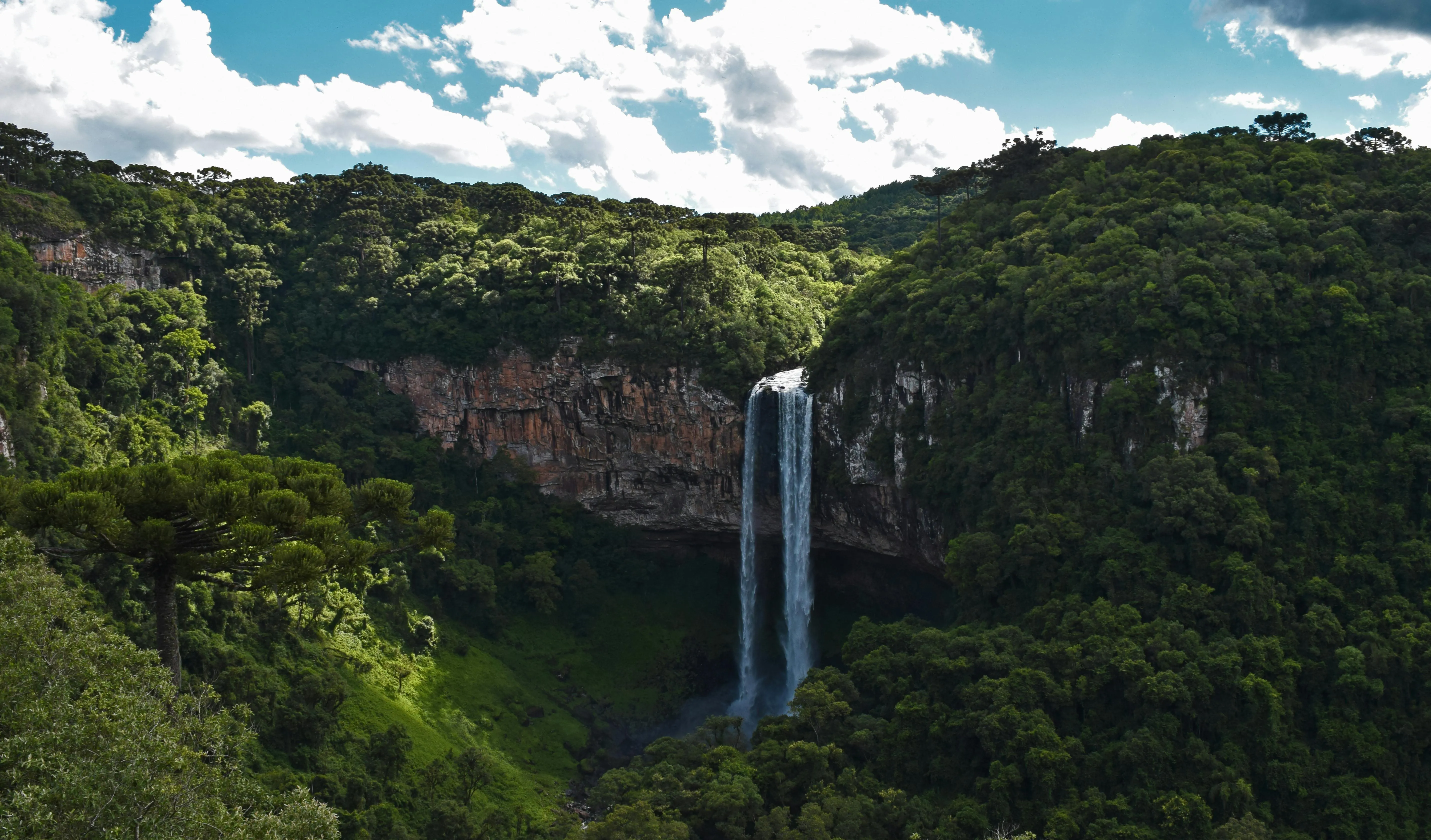 Tall Waterfall in a Tropical Forest with Blue Sky Wallpaper