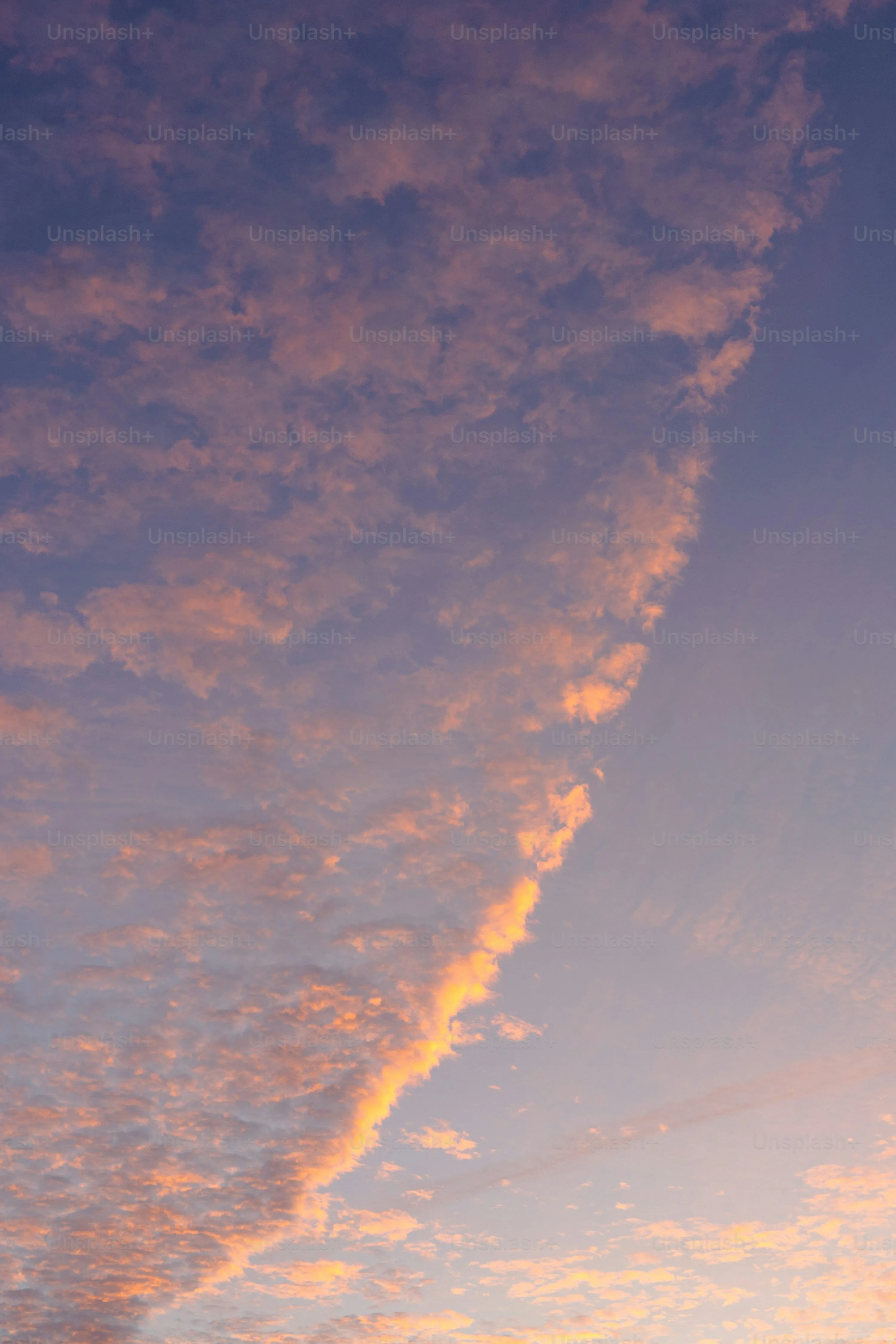 Thin Streaks of Orange Clouds Against Blue Evening Sky
