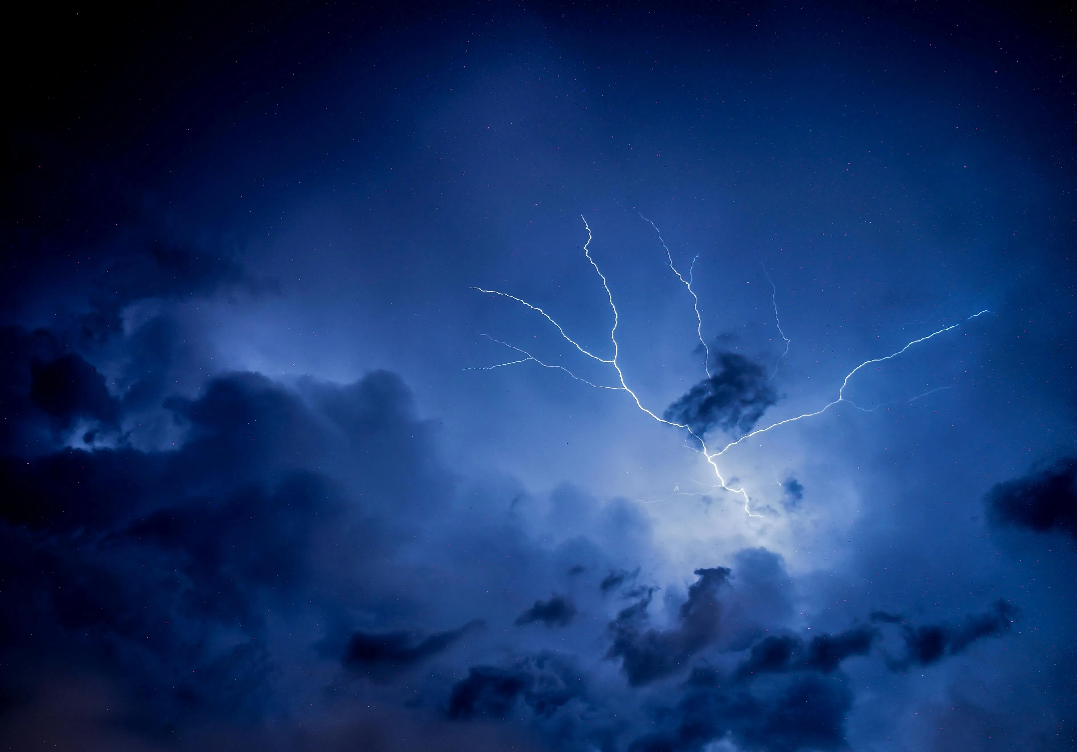 Thunderstorm with Lightning Strikes Behind Clouds Image
