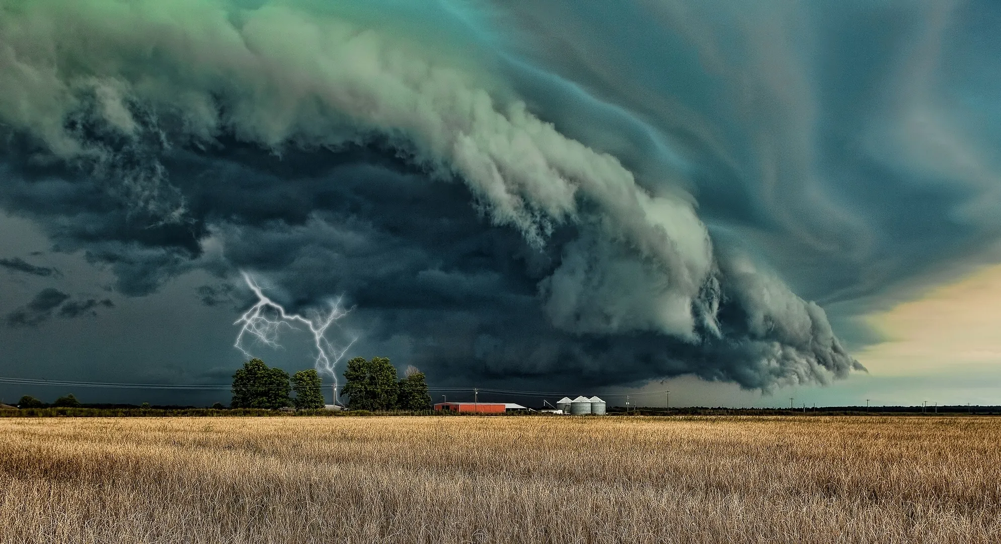 Tornado Forming Under Green Clouds Across Rural Farmland