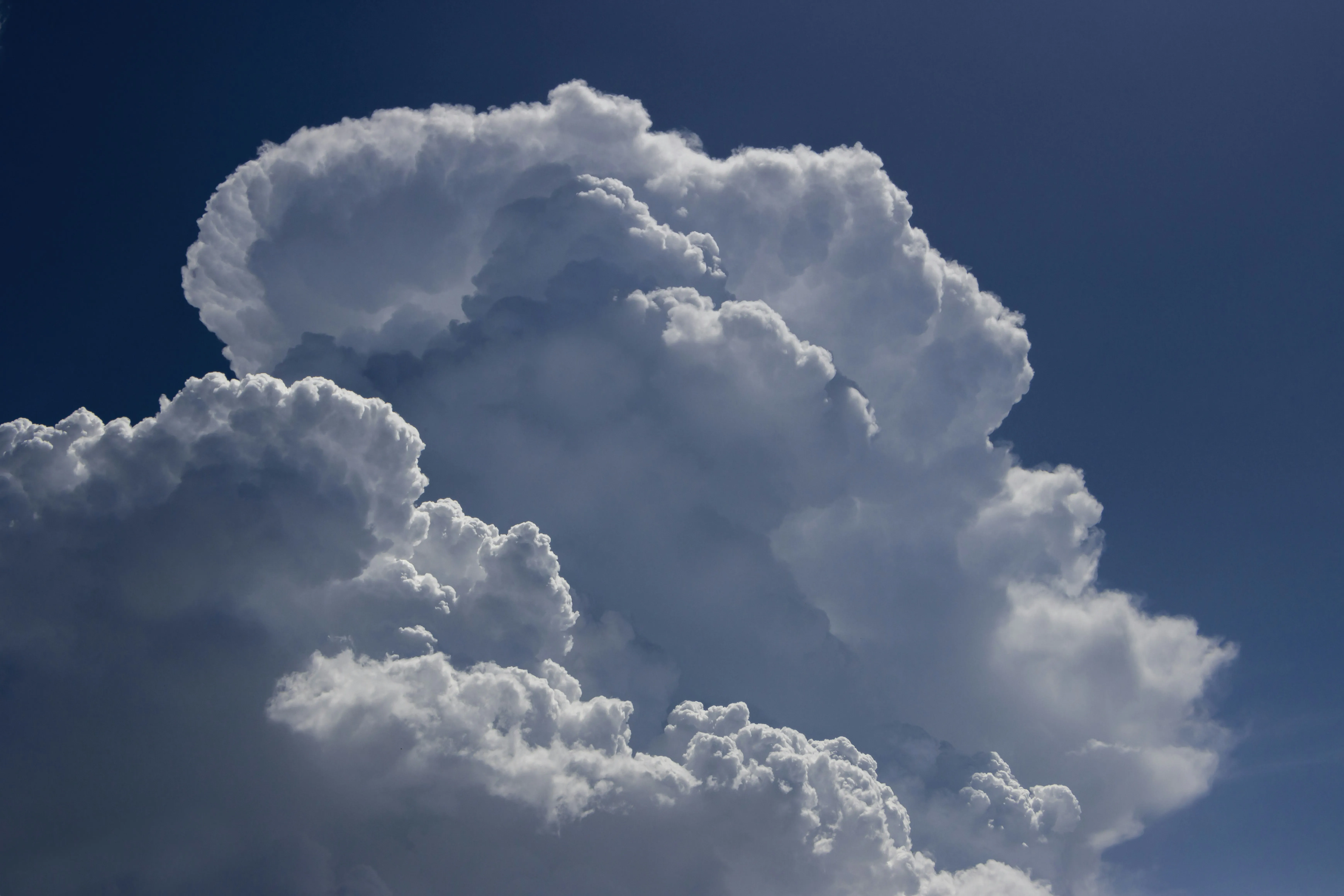 Towering Cumulus Clouds Against Deep Blue Sky Wallpaper