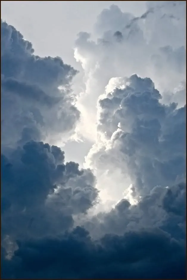 Towering Cumulus Clouds in Moody Blue Sky Background