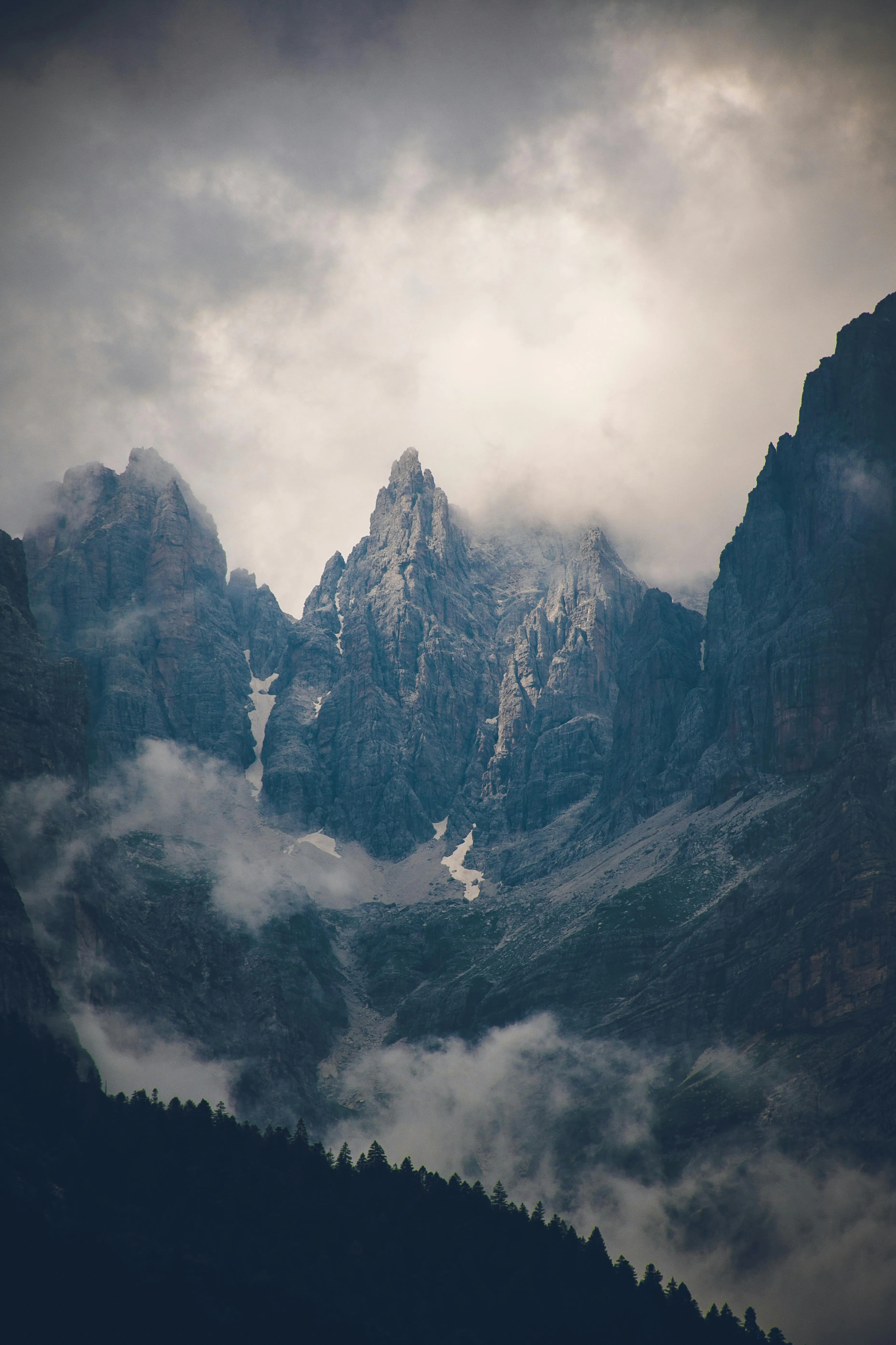 Towering Rocky Mountains Partially Covered By Dark Clouds
