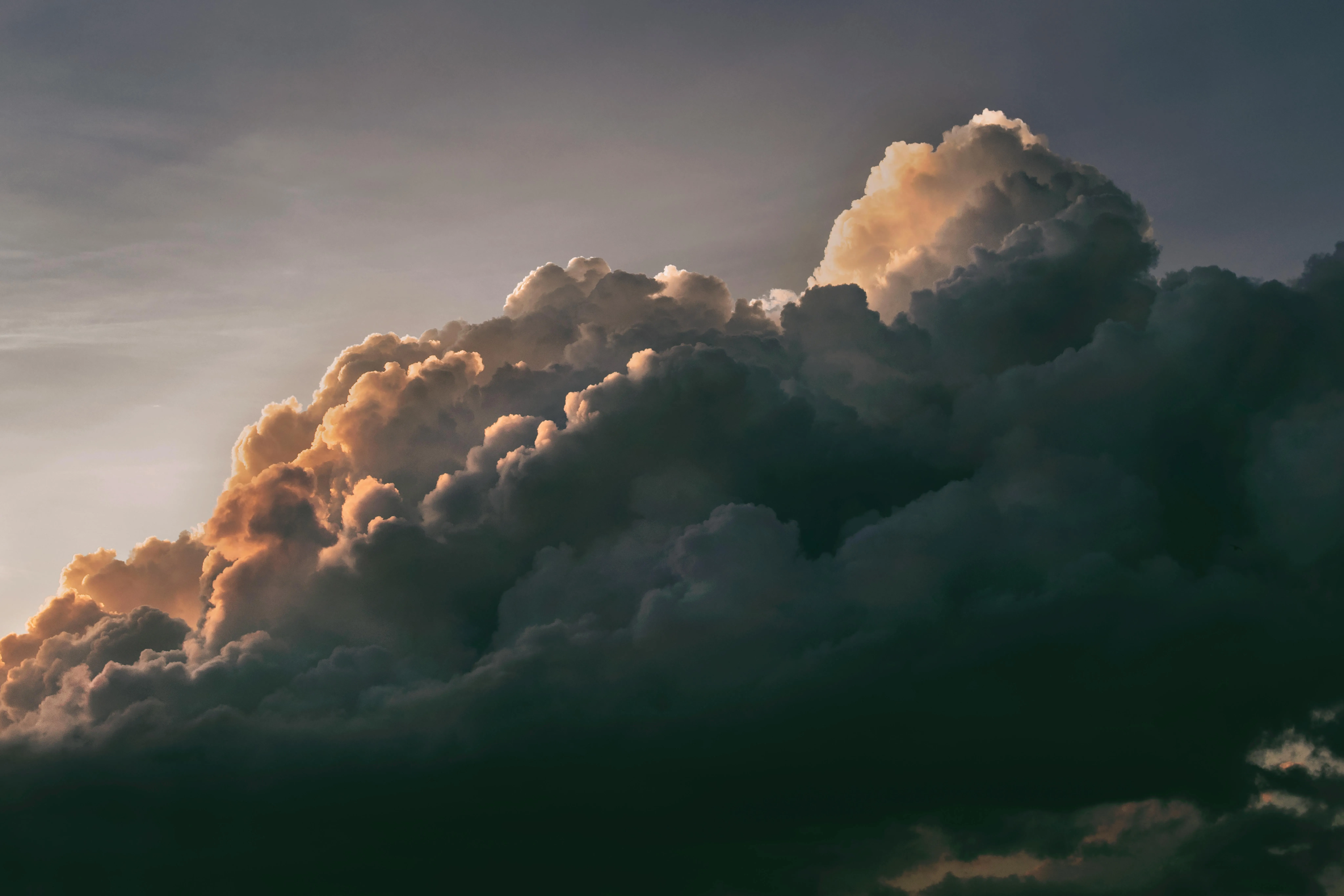 Towering Thunderclouds Over Hills in Evening Golden Light